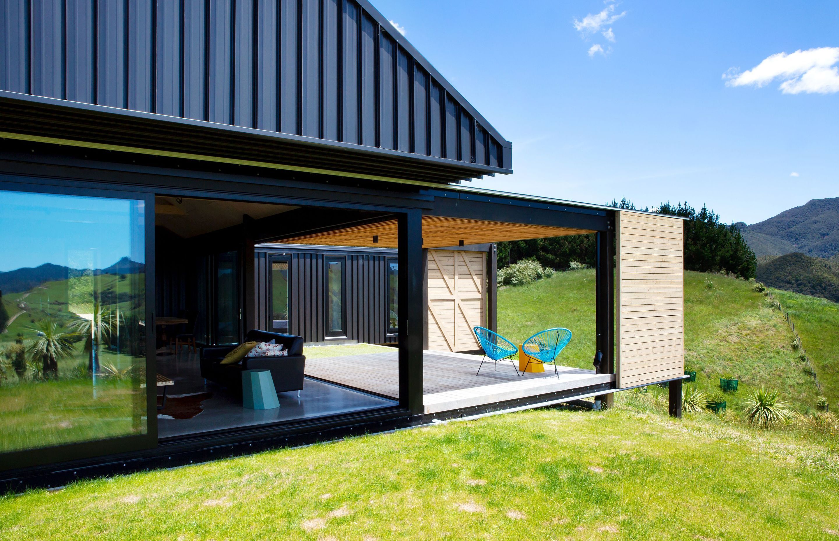 A floating gabled roof encloses a central pavillion containing the public spaces of the house, the kitchen, dining and living area from which a covered deck extends out to the west. 