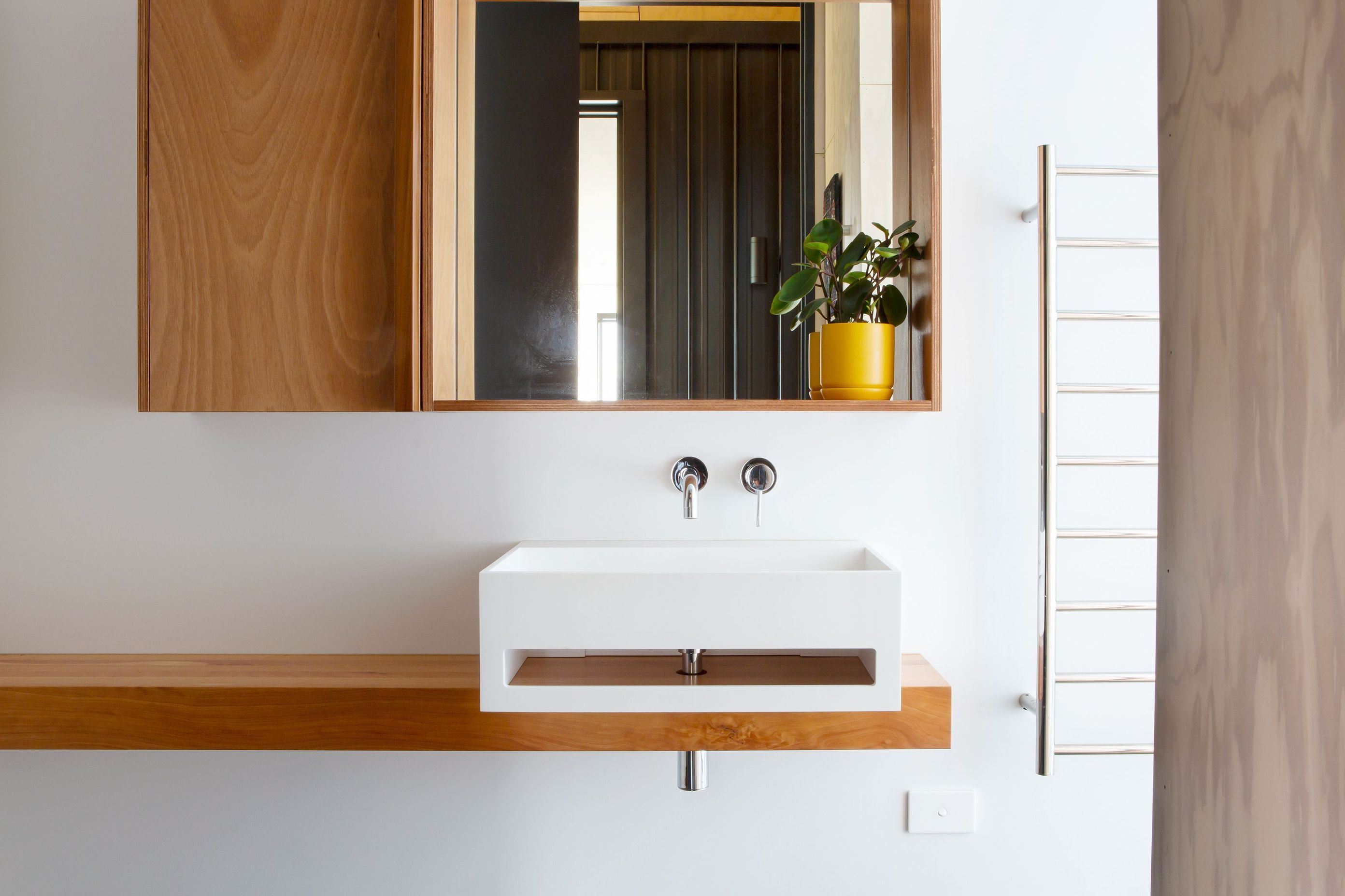 Like the rest of the house, the bathroom is defined by a simple, natural material palette. 