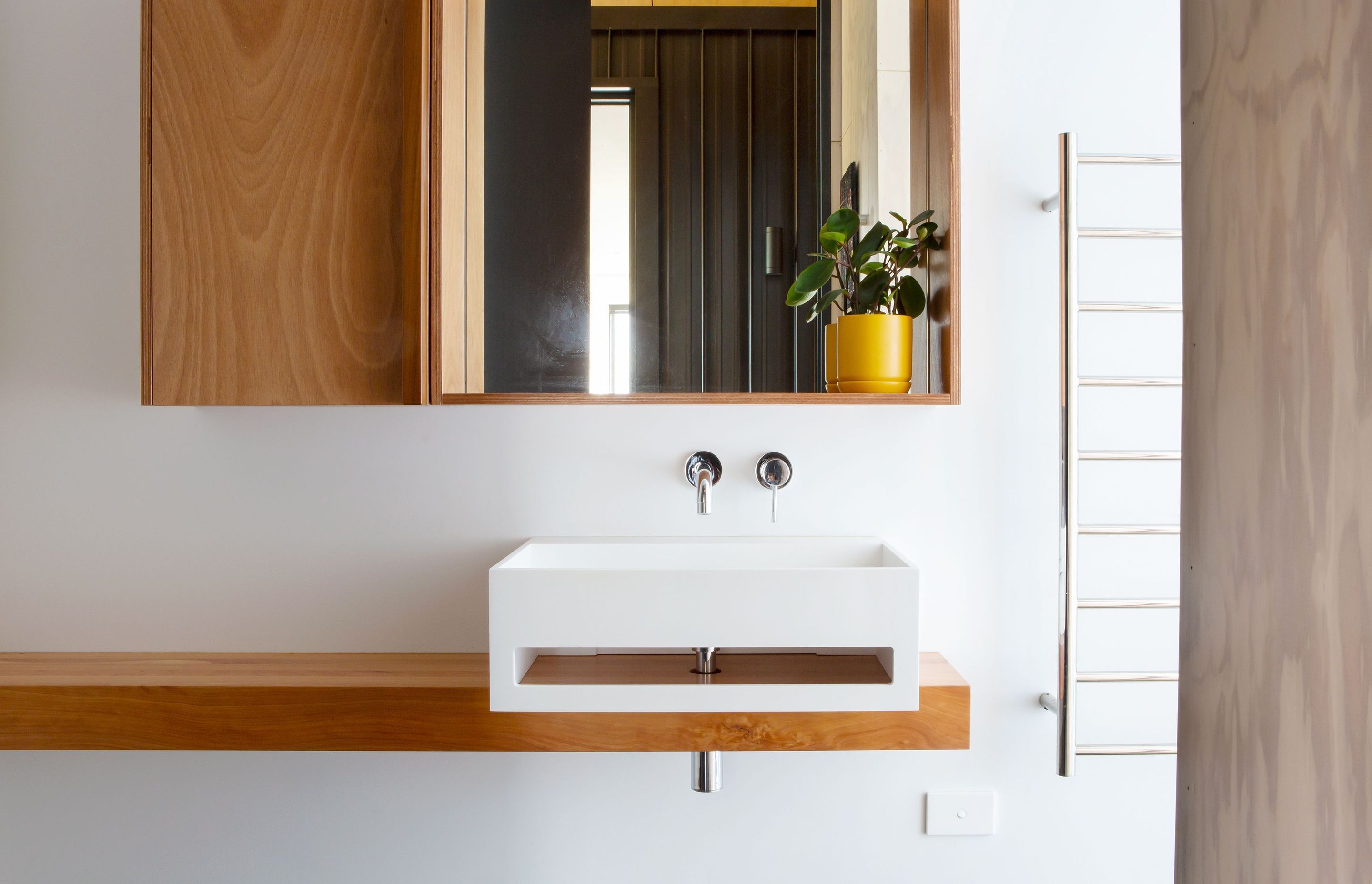 Like the rest of the house, the bathroom is defined by a simple, natural material palette. 