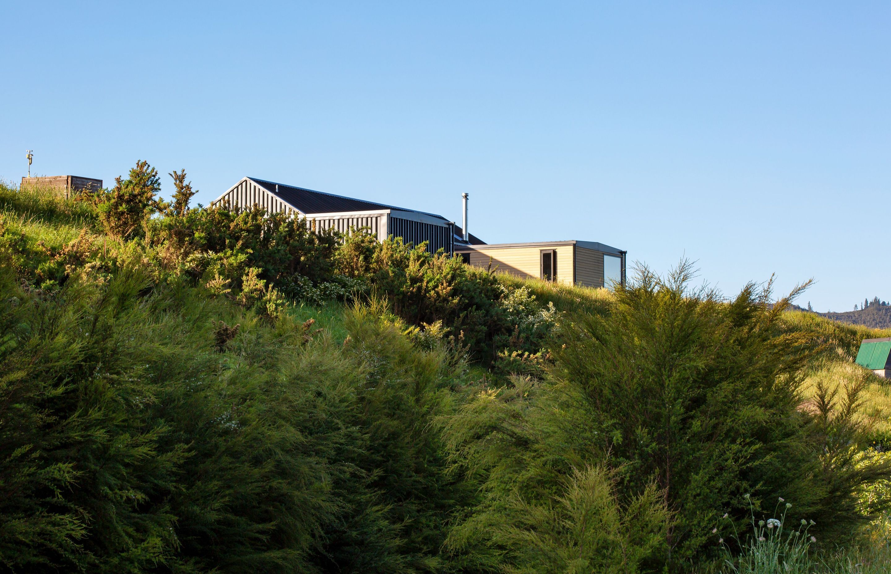 Perched on a knoll overlooking sleepy farmland and an alluvial valley, the site looks out to The Pinnacles and to the Tairua River.