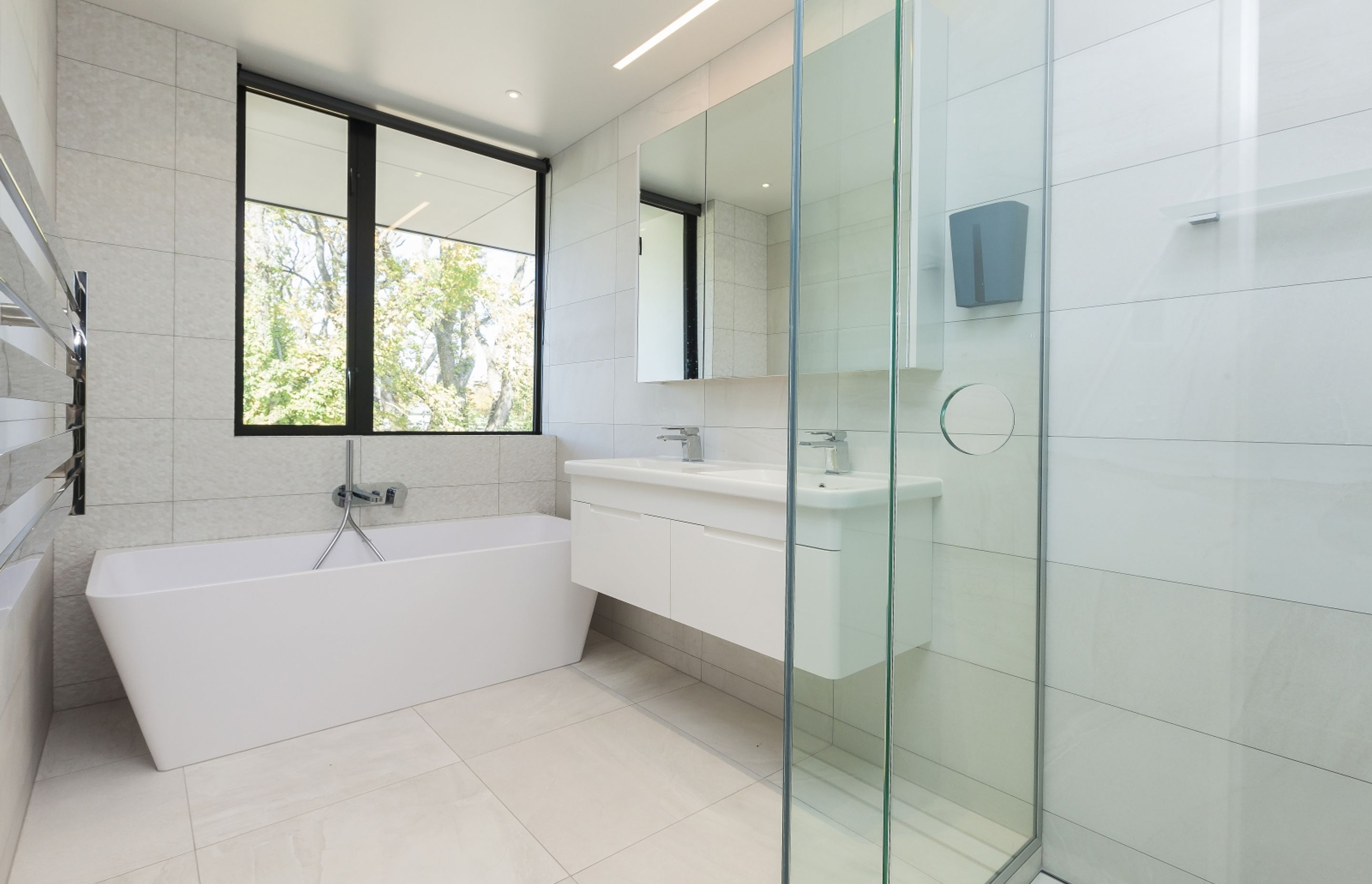 The guest bathroom features an all-white scheme for a light, bright and airy feel.