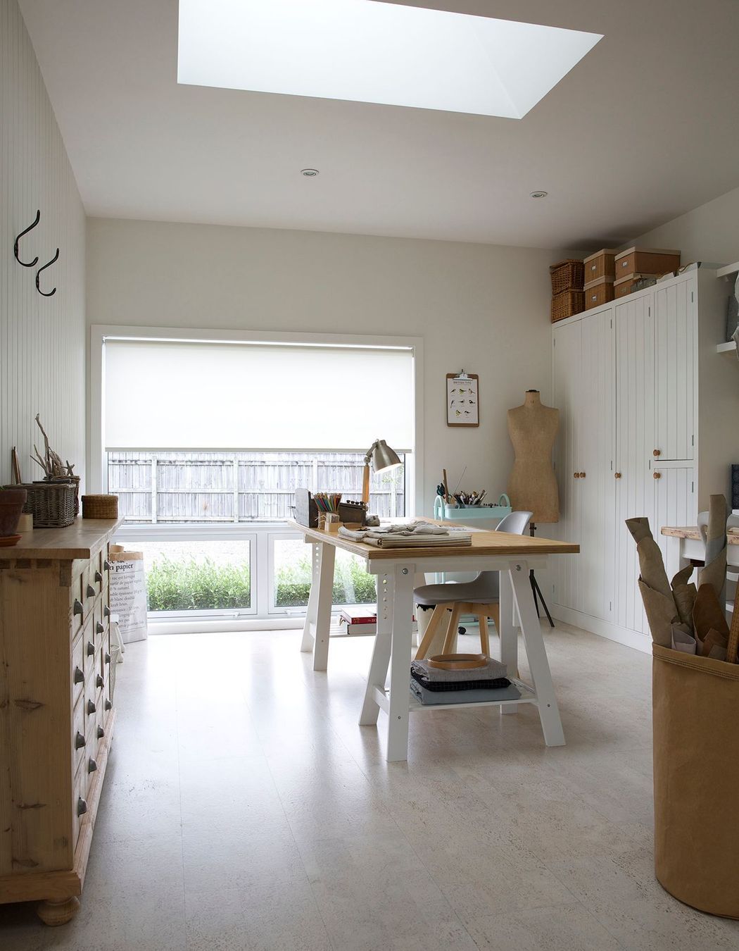 A lightwell in the ceiling of the sewing studio pulls natural sunlight in and over the desk.