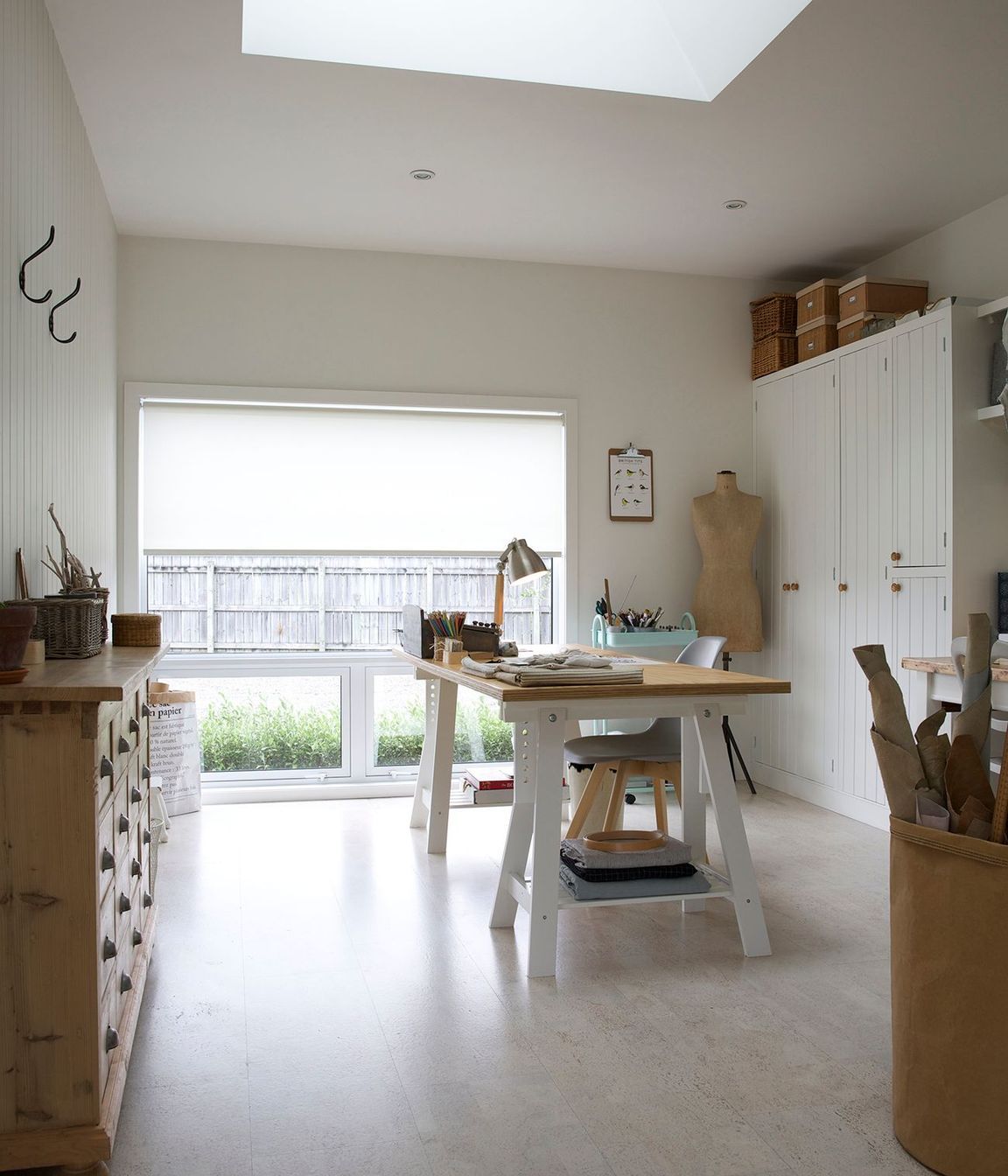 A lightwell in the ceiling of the sewing studio pulls natural sunlight in and over the desk.