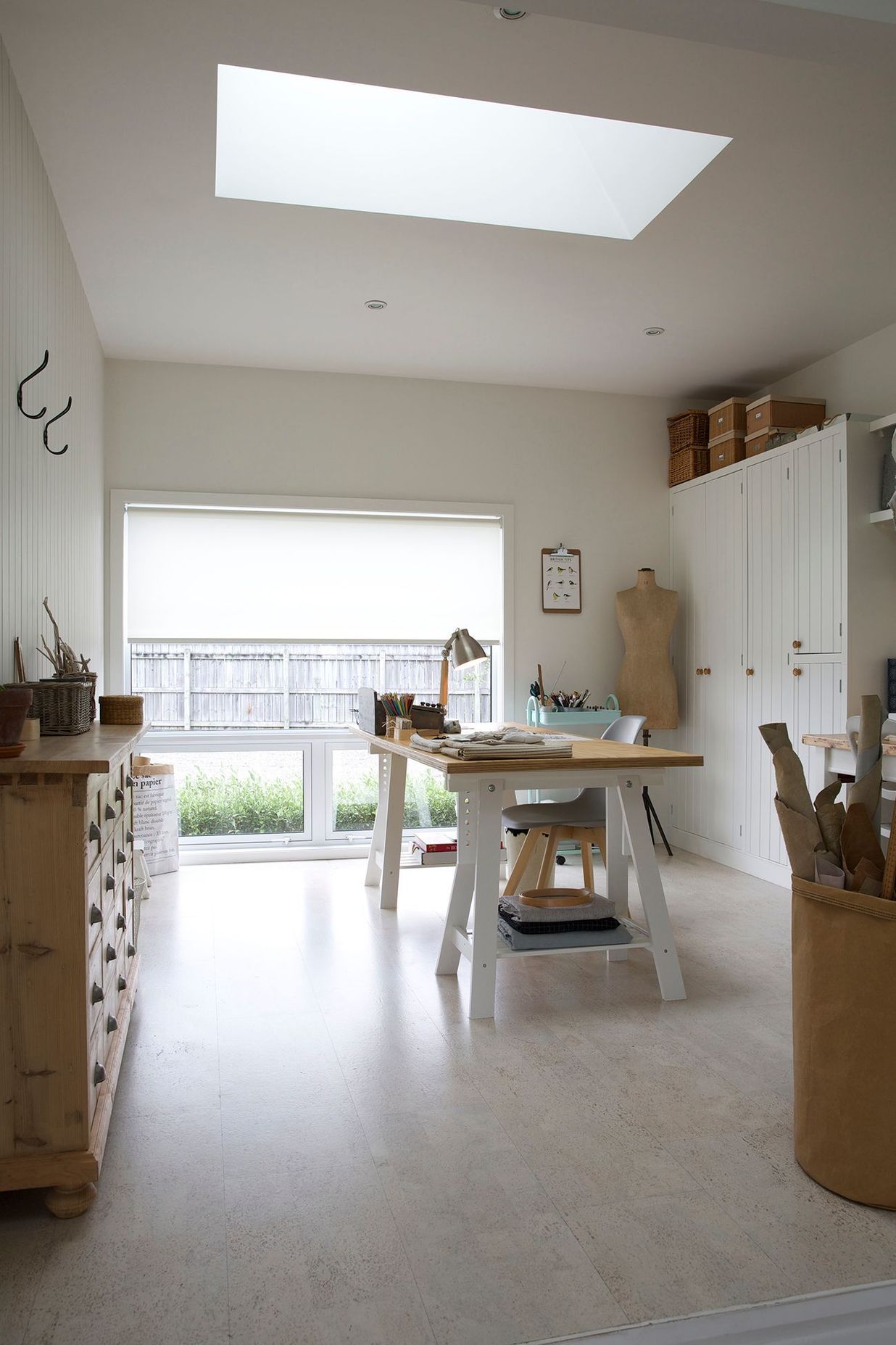 A lightwell in the ceiling of the sewing studio pulls natural sunlight in and over the desk.