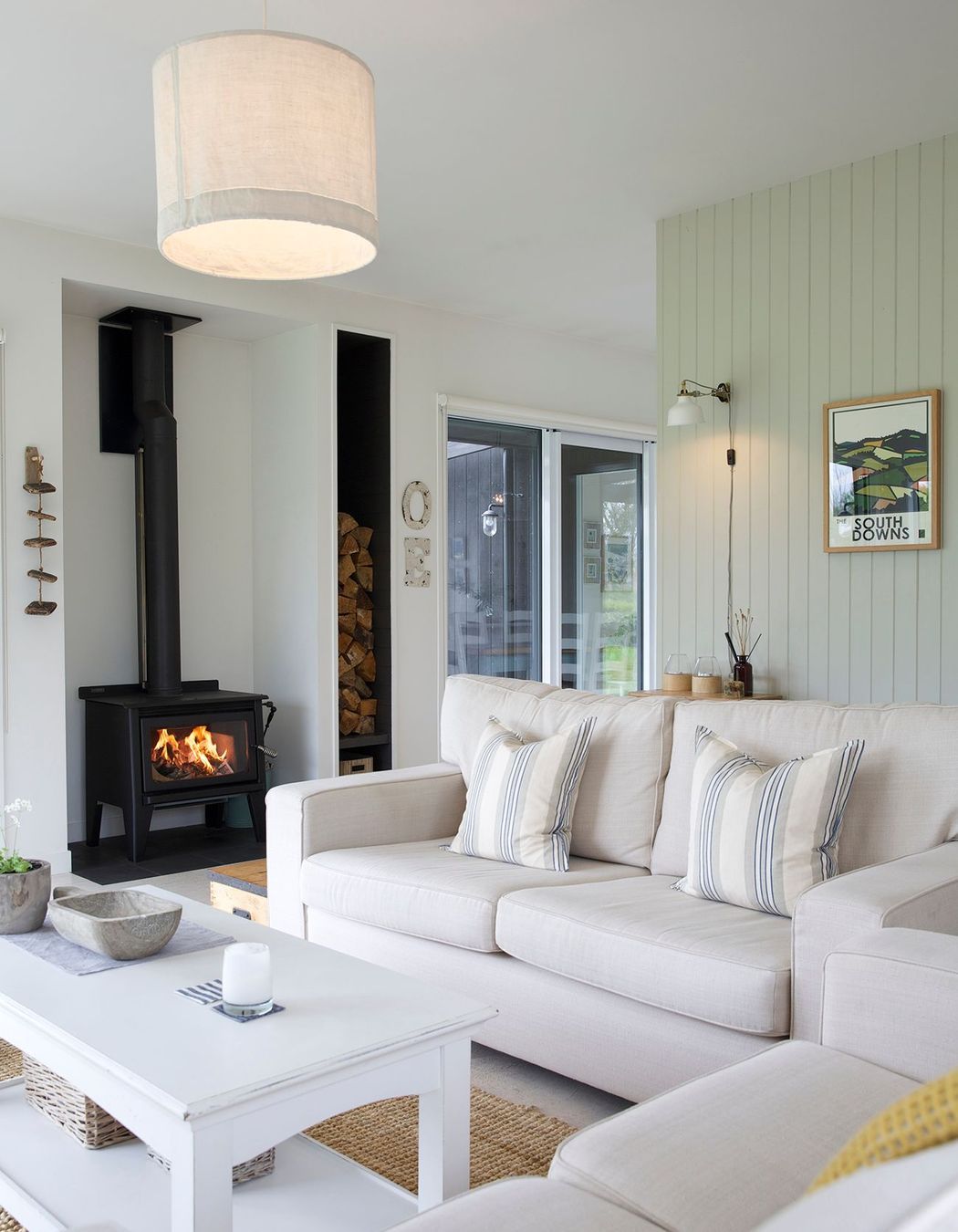 The cosy lounge area features a wood-burning fire and timber-panelled walls.