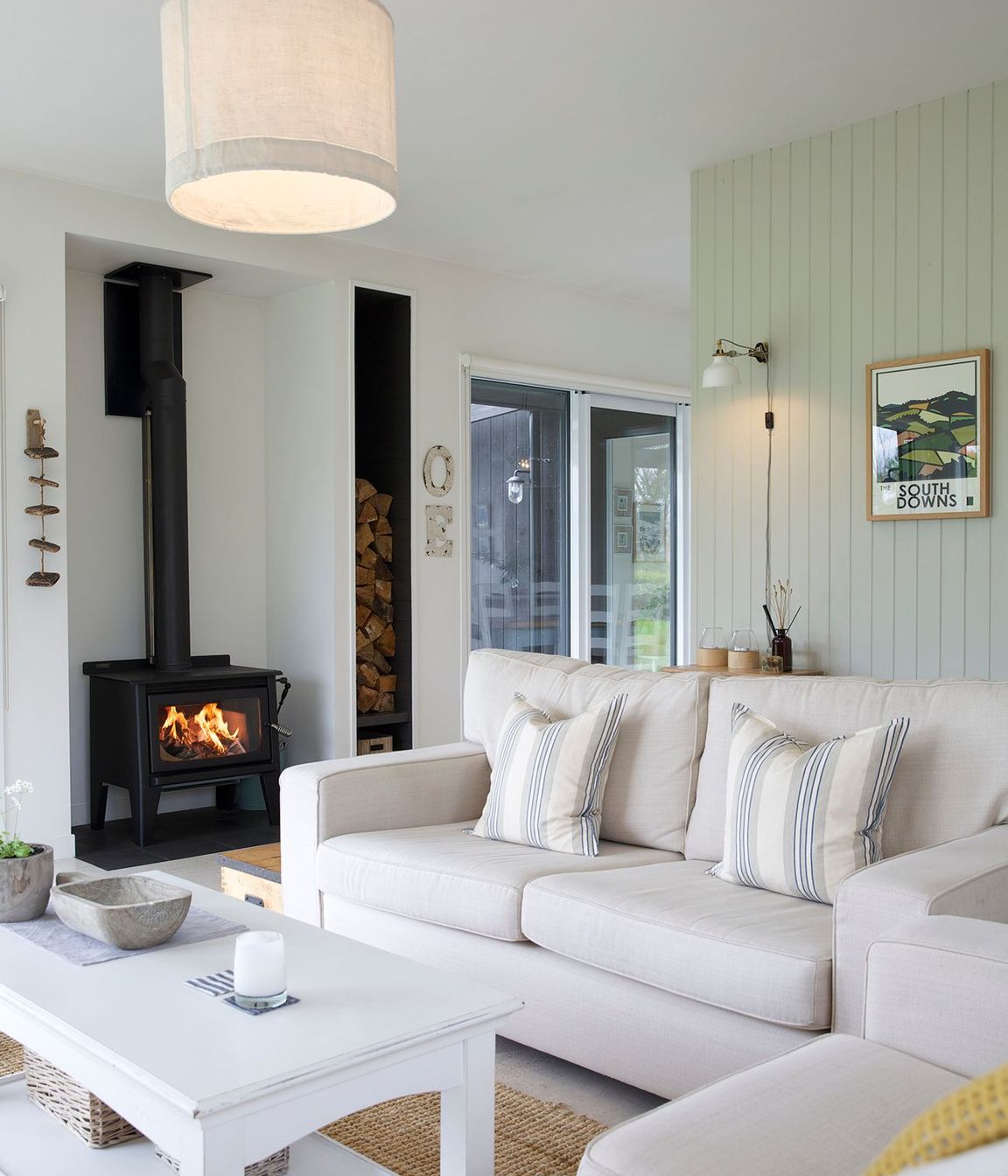 The cosy lounge area features a wood-burning fire and timber-panelled walls.