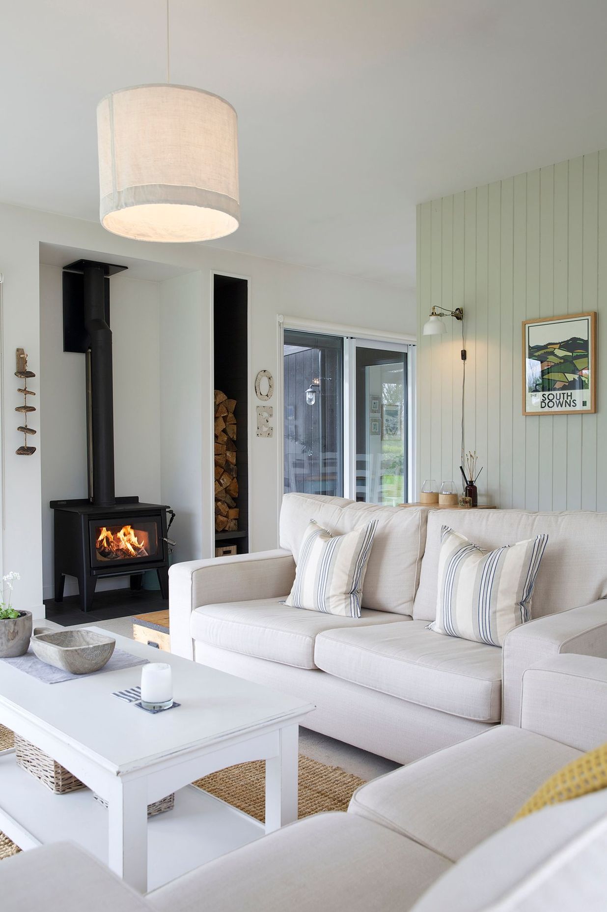 The cosy lounge area features a wood-burning fire and timber-panelled walls.