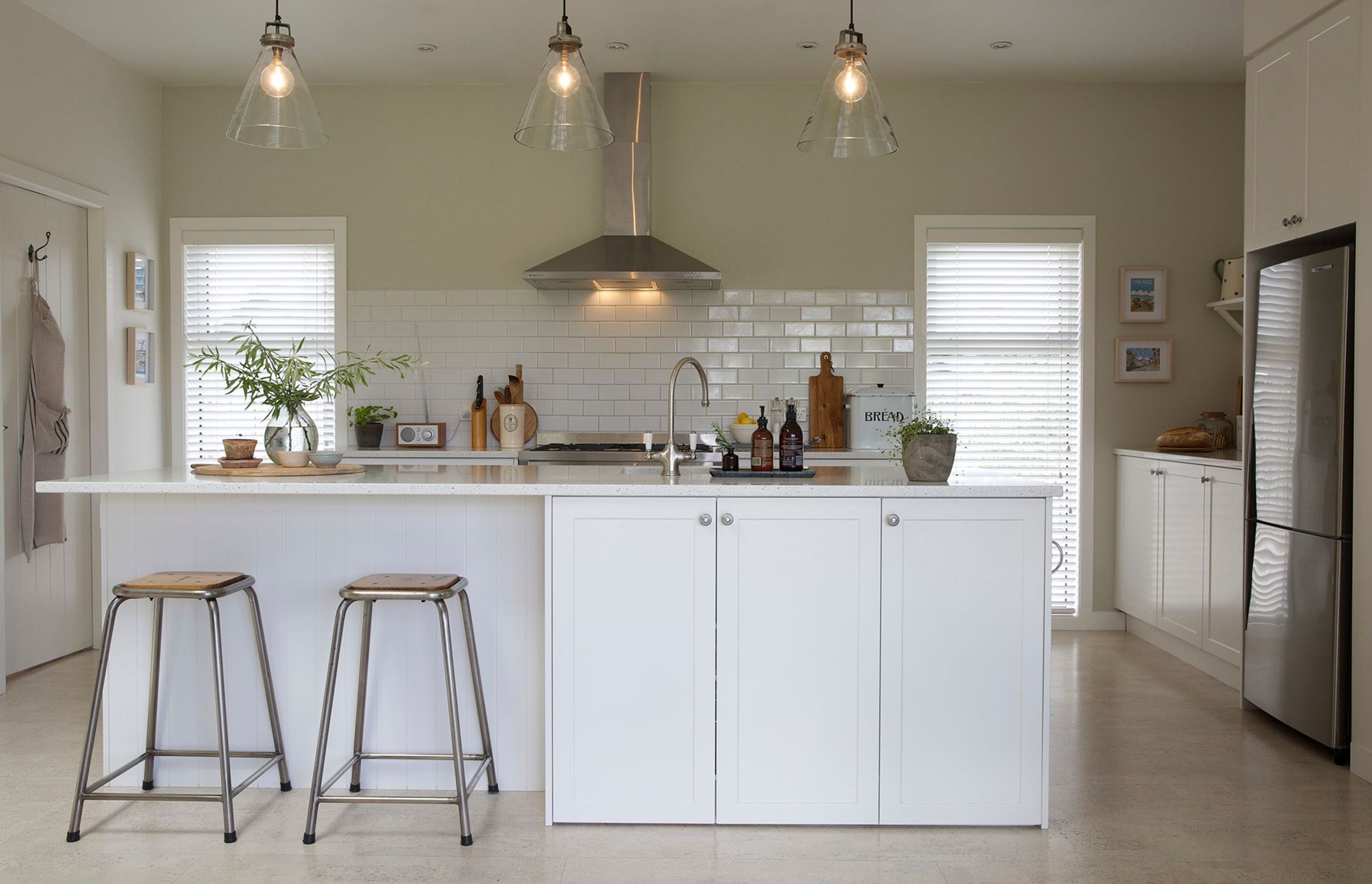 In true farmhouse style, this timeless kitchen is super functional with a large island, laid out for easy access with lots of low cupboards and the laundry situated behind the door on the left.