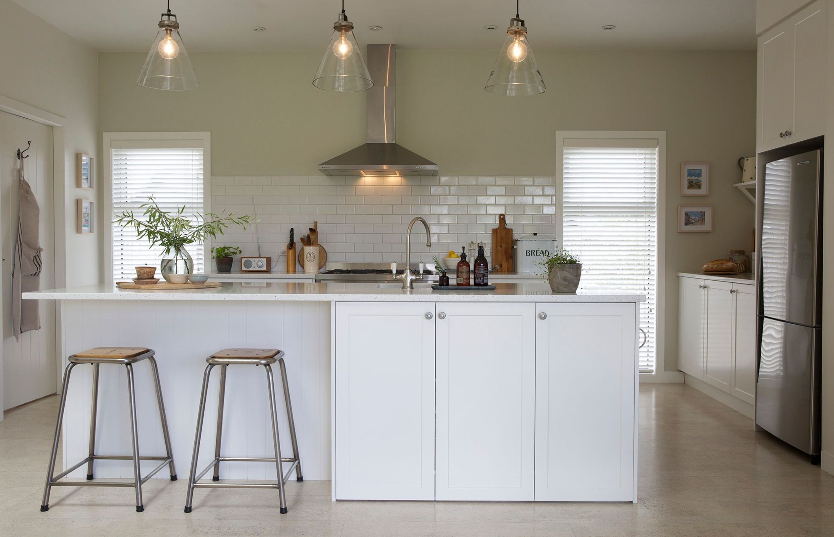 In true farmhouse style, this timeless kitchen is super functional with a large island, laid out for easy access with lots of low cupboards and the laundry situated behind the door on the left.