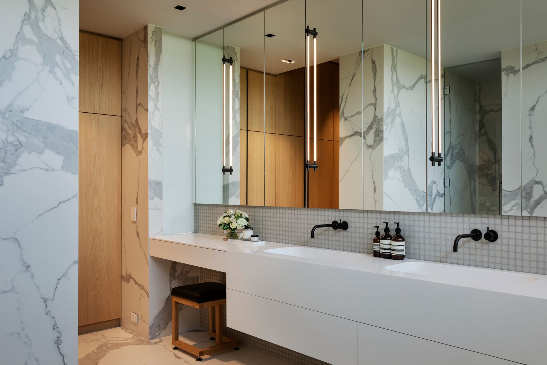 White and black marble is carried through into the elegant ensuite bathroom, seen on walls and flooring.