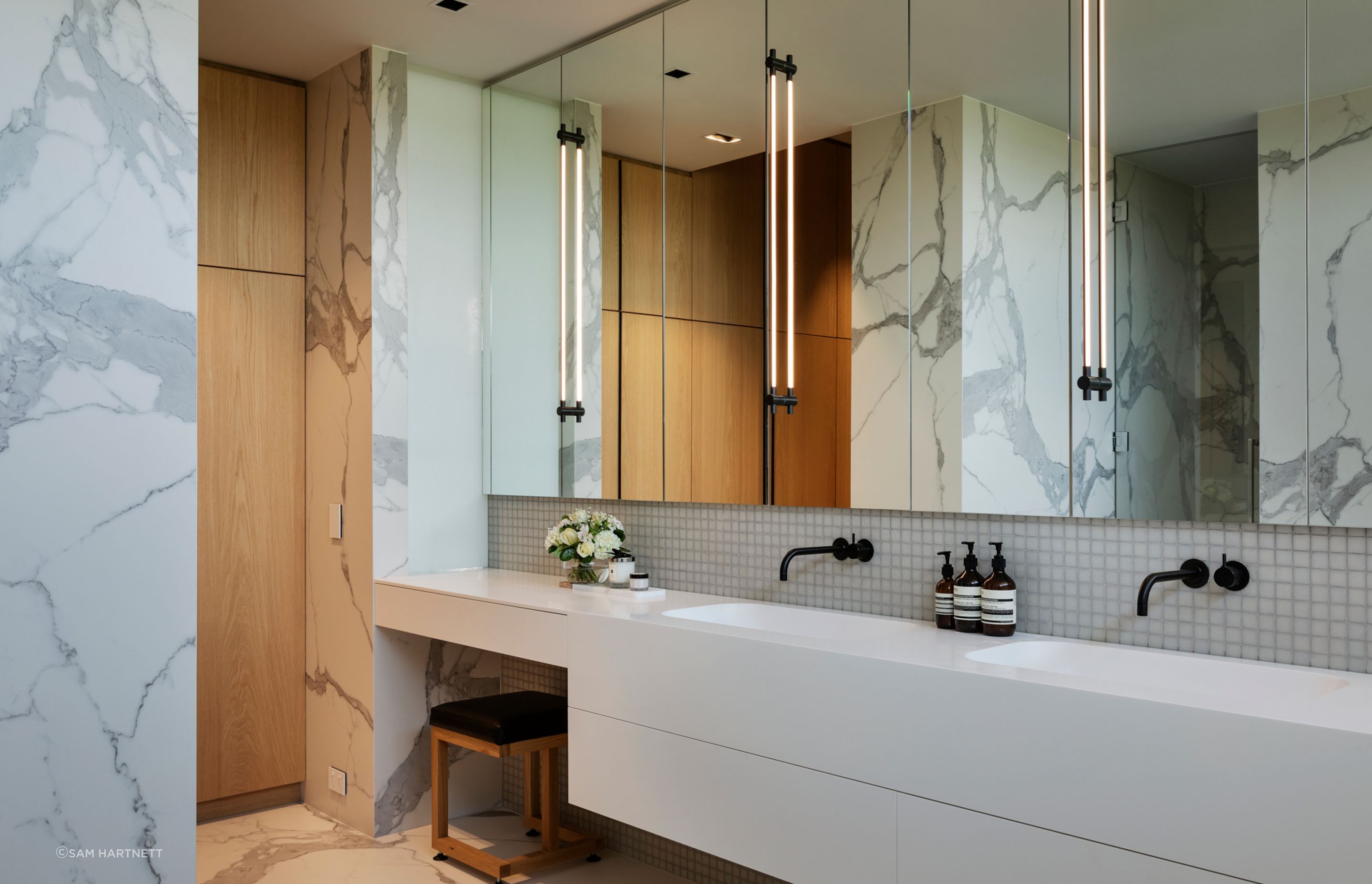 White and black marble is carried through into the elegant ensuite bathroom, seen on walls and flooring.