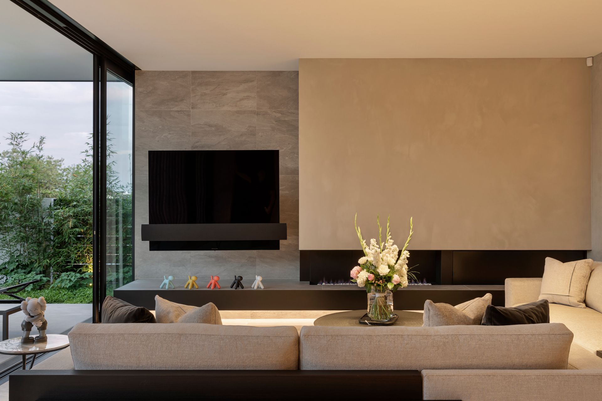 The lounge is a cleverly curated modernist composition of fireplace, large-scale television, sofas and coffee table.