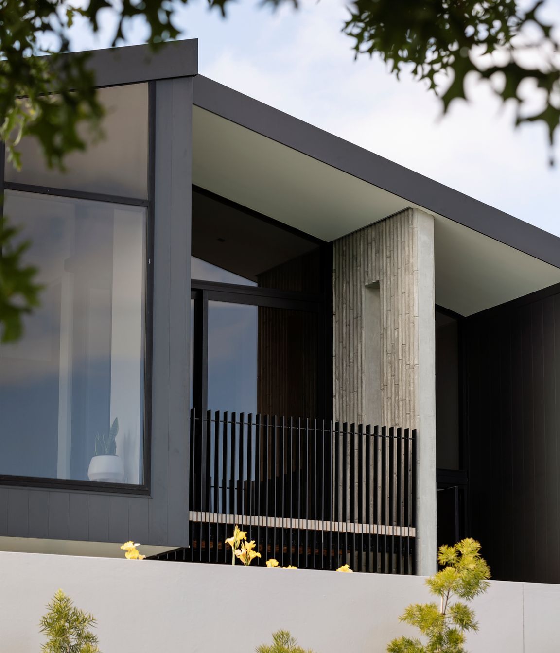 The first-floor balcony is edged with a unique bamboo-patterned concrete wall.