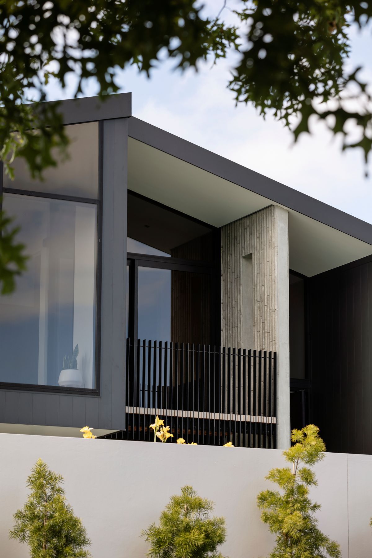 The first-floor balcony is edged with a unique bamboo-patterned concrete wall.