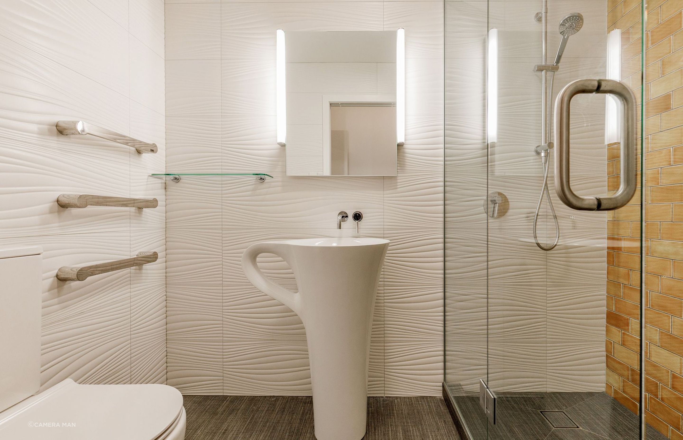 All elements for this guest bathroom were chosen to reflect a sense of relaxation with the connection to sun, sand and water in mind. MIDDLE EARTH TILES GOLDEN MANUKA 150 X 75 SUBWAY TILE LAID WITH 33% OFFSET were chosen to reflect the colour of the sun. TILE SPACE DUNES BLANCO MATT 300X900 POR094 600045 TO ALL OTHER BATHROOM WALLS was chosen to reflect waves and sand dunes. The tiles create such a wonderful look that is subtle yet still very interesting to look at. TILE SPACE TAILORART BROWN 600X600 CSA019 to the floor was chosen to reflect a textured fabric, like a blanket used on the beach.