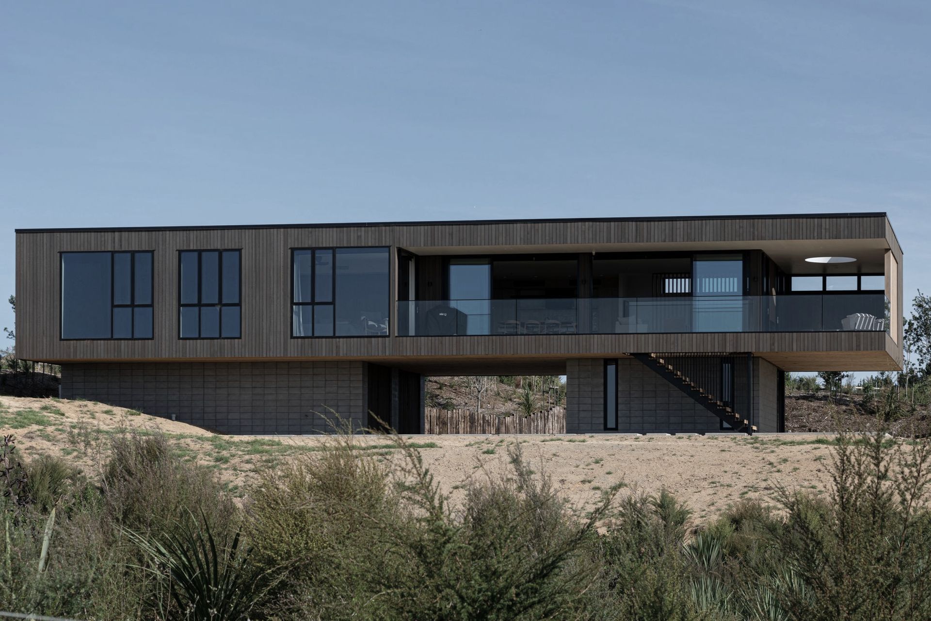 Complex engineering was required to cantilever the main box form out over the plinth in two directions to create the sense that the house is floating in space.
