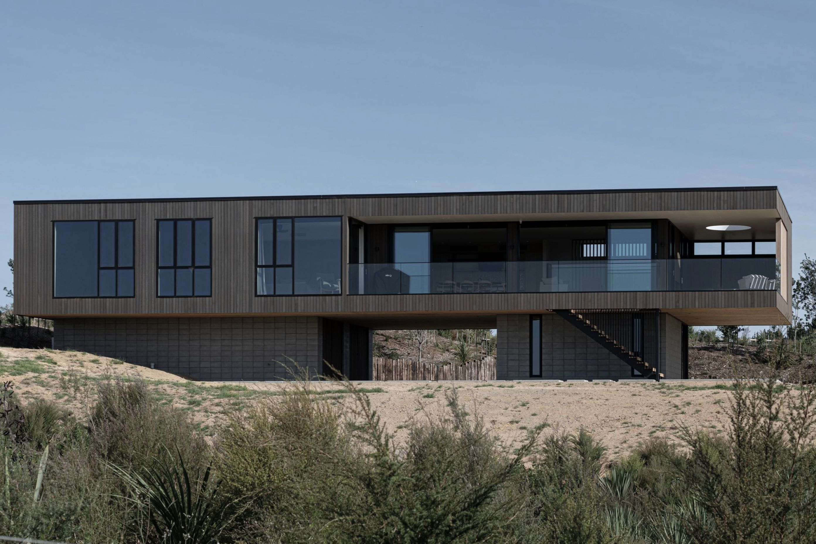 Complex engineering was required to cantilever the main box form out over the plinth in two directions to create the sense that the house is floating in space.