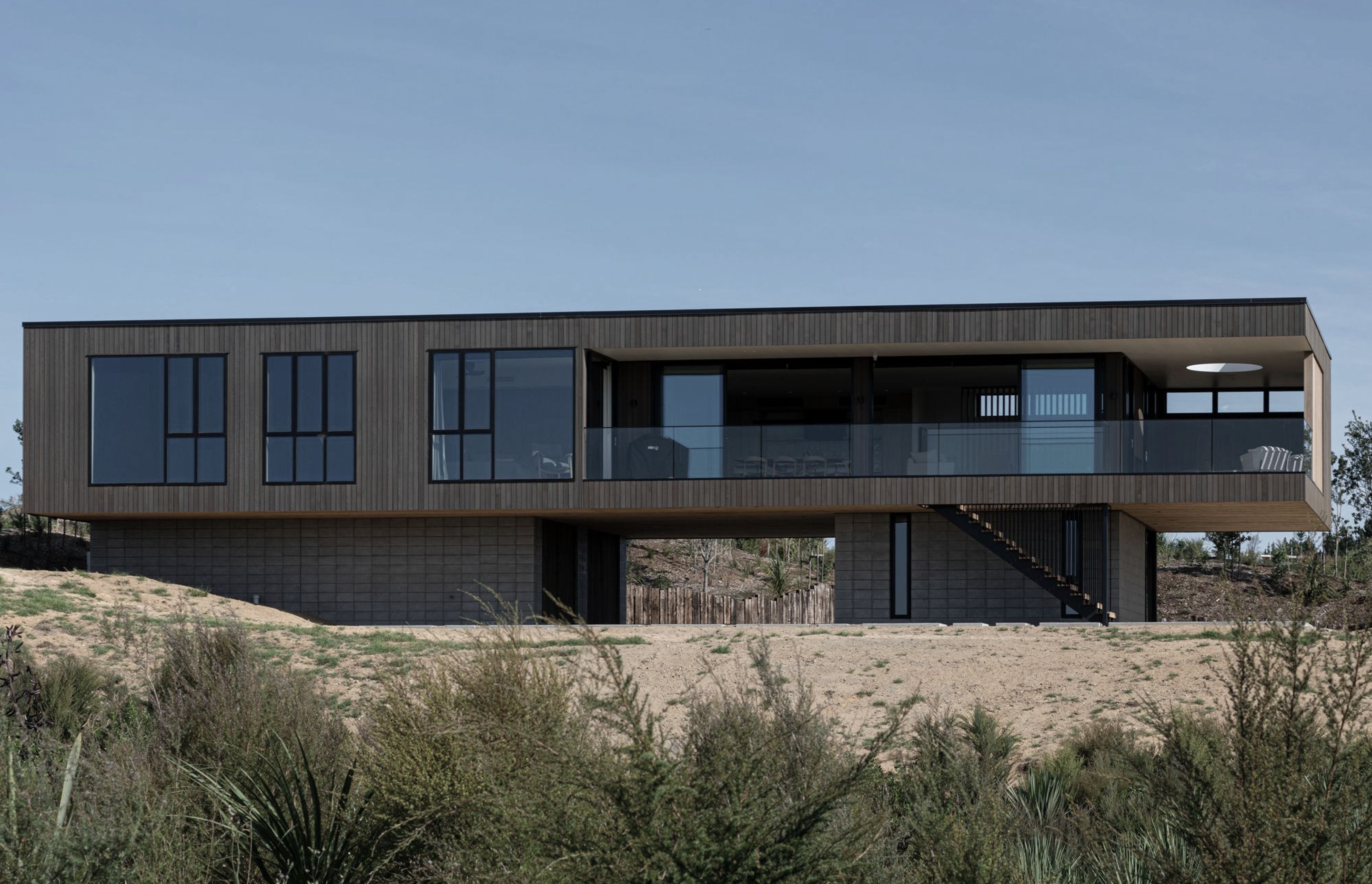 Complex engineering was required to cantilever the main box form out over the plinth in two directions to create the sense that the house is floating in space.