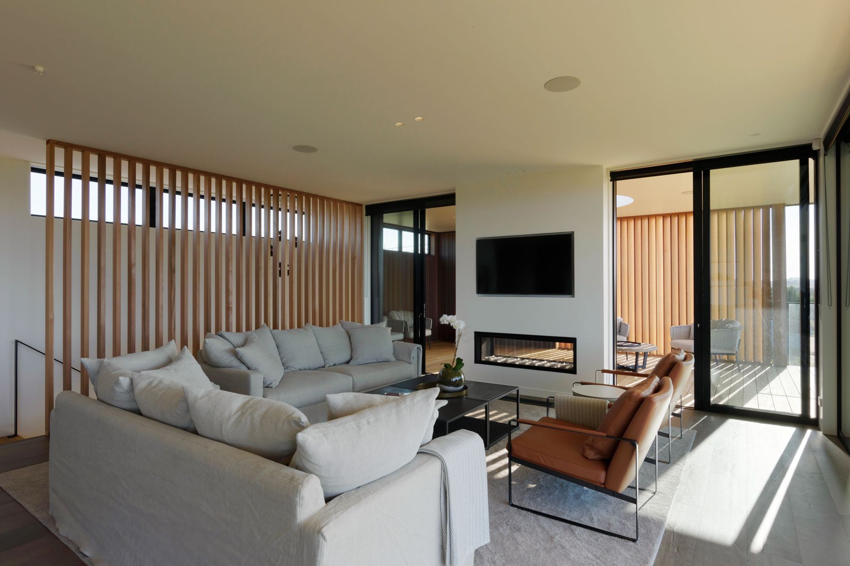 A double-sided fireplace sits at the junction between indoor and outdoor living areas.