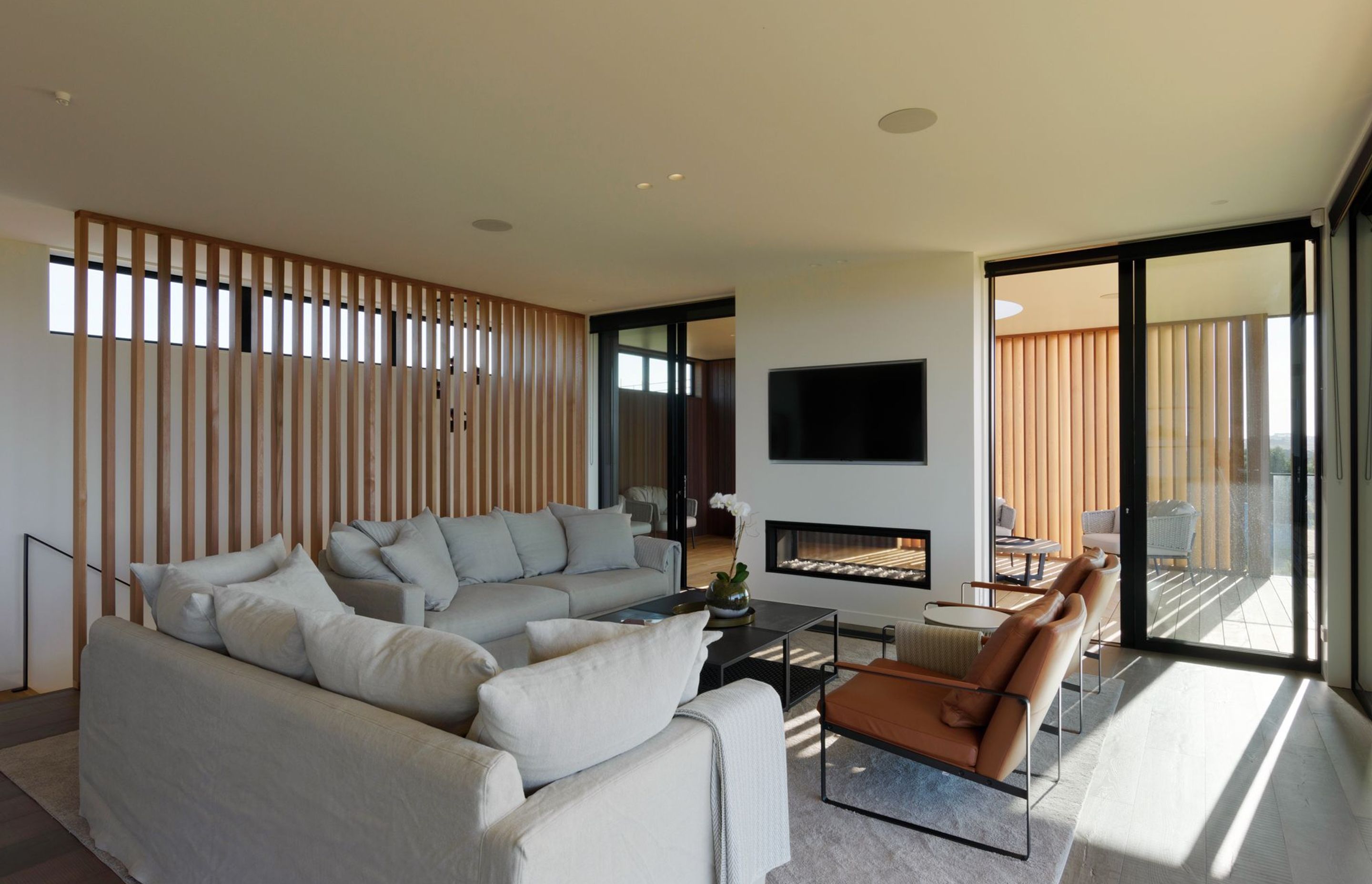 A double-sided fireplace sits at the junction between indoor and outdoor living areas.
