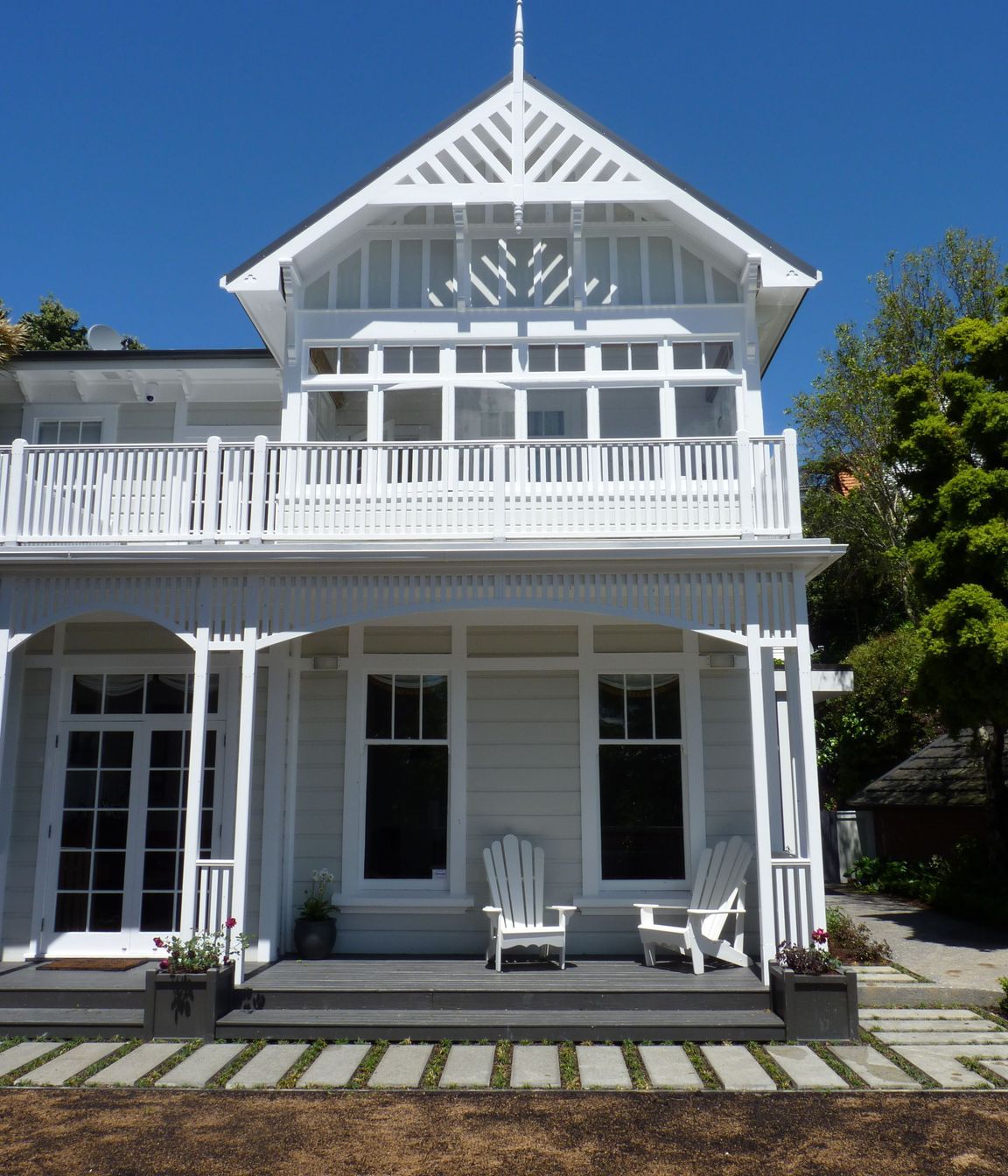We opened up the verandah to the lawn, installed bottomless built-in Versailles planter boxes &amp; wires for 2 storey tall climbing roses, Cape Cod chairs for gins, and new custom pavers edged in mondo grass, new lawn, Kelburn.