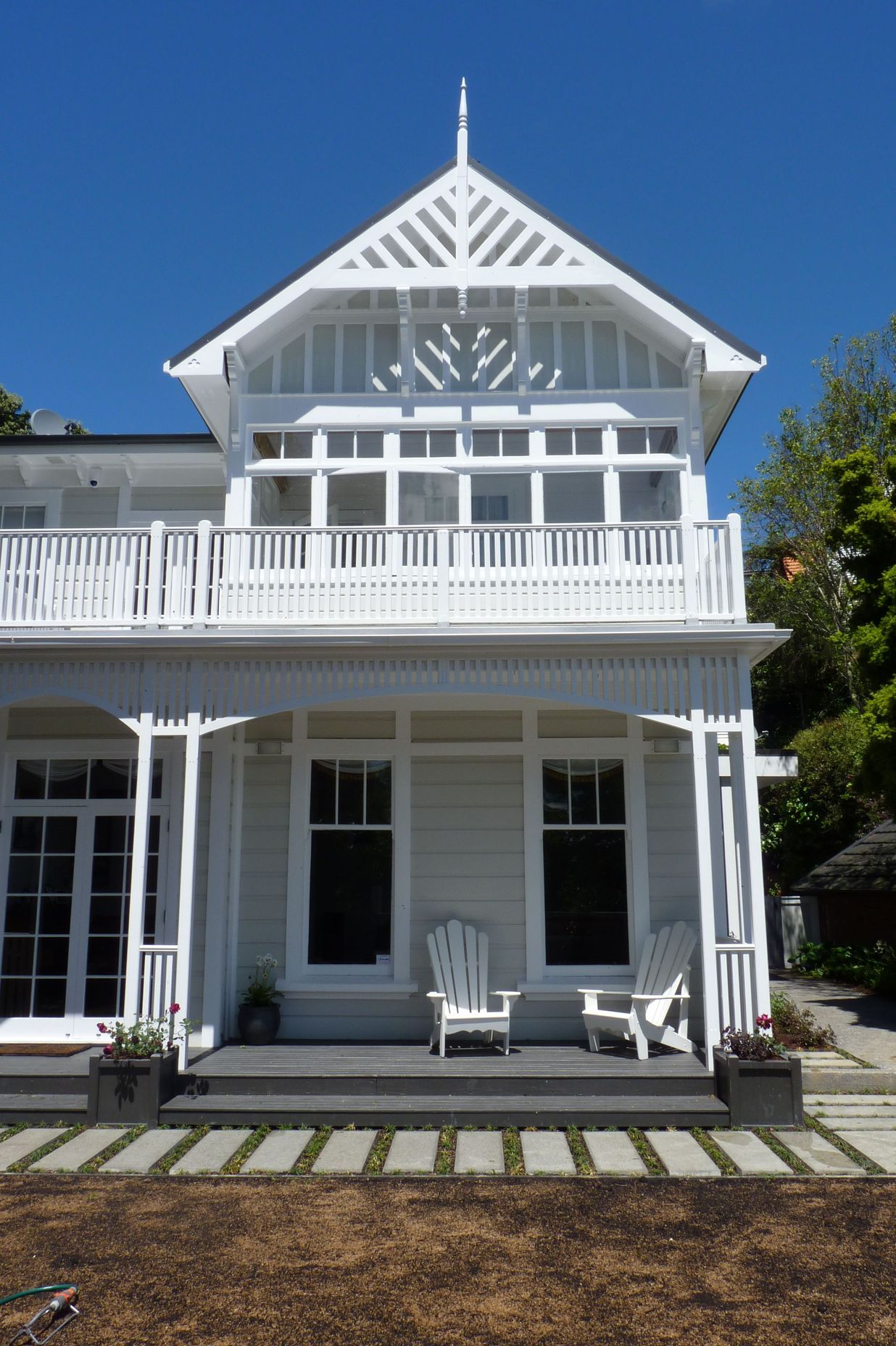 We opened up the verandah to the lawn, installed bottomless built-in Versailles planter boxes &amp; wires for 2 storey tall climbing roses, Cape Cod chairs for gins, and new custom pavers edged in mondo grass, new lawn, Kelburn.