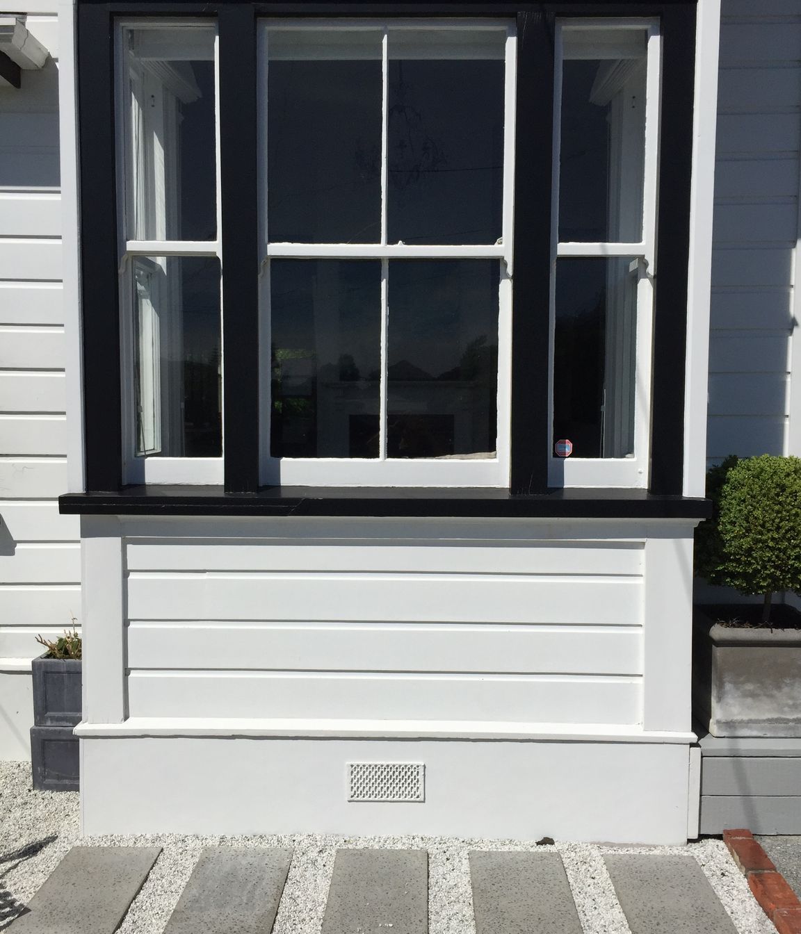 Pavers in white pebbles against black &amp; white detailed villa, Northland.