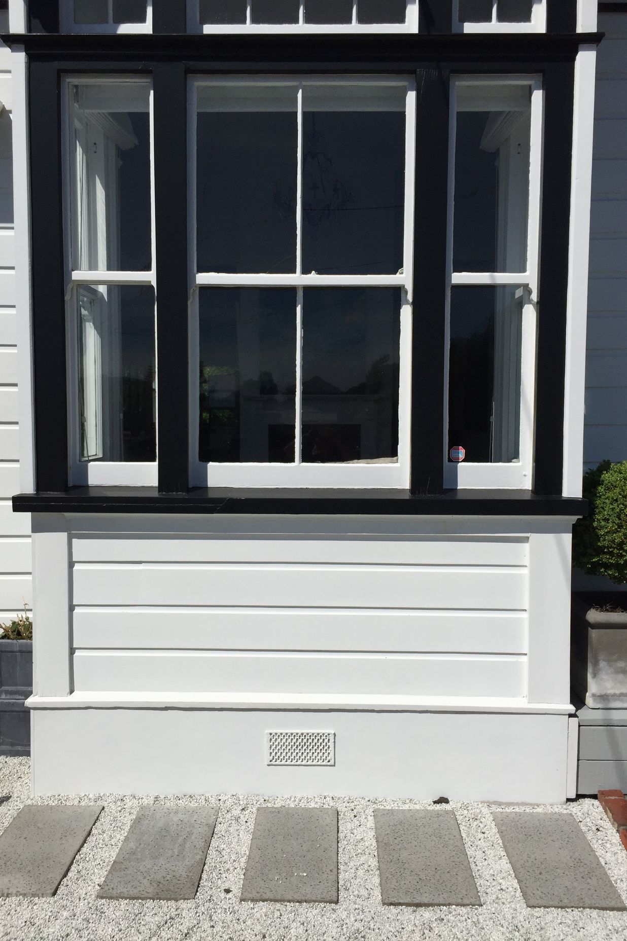 Pavers in white pebbles against black &amp; white detailed villa, Northland.