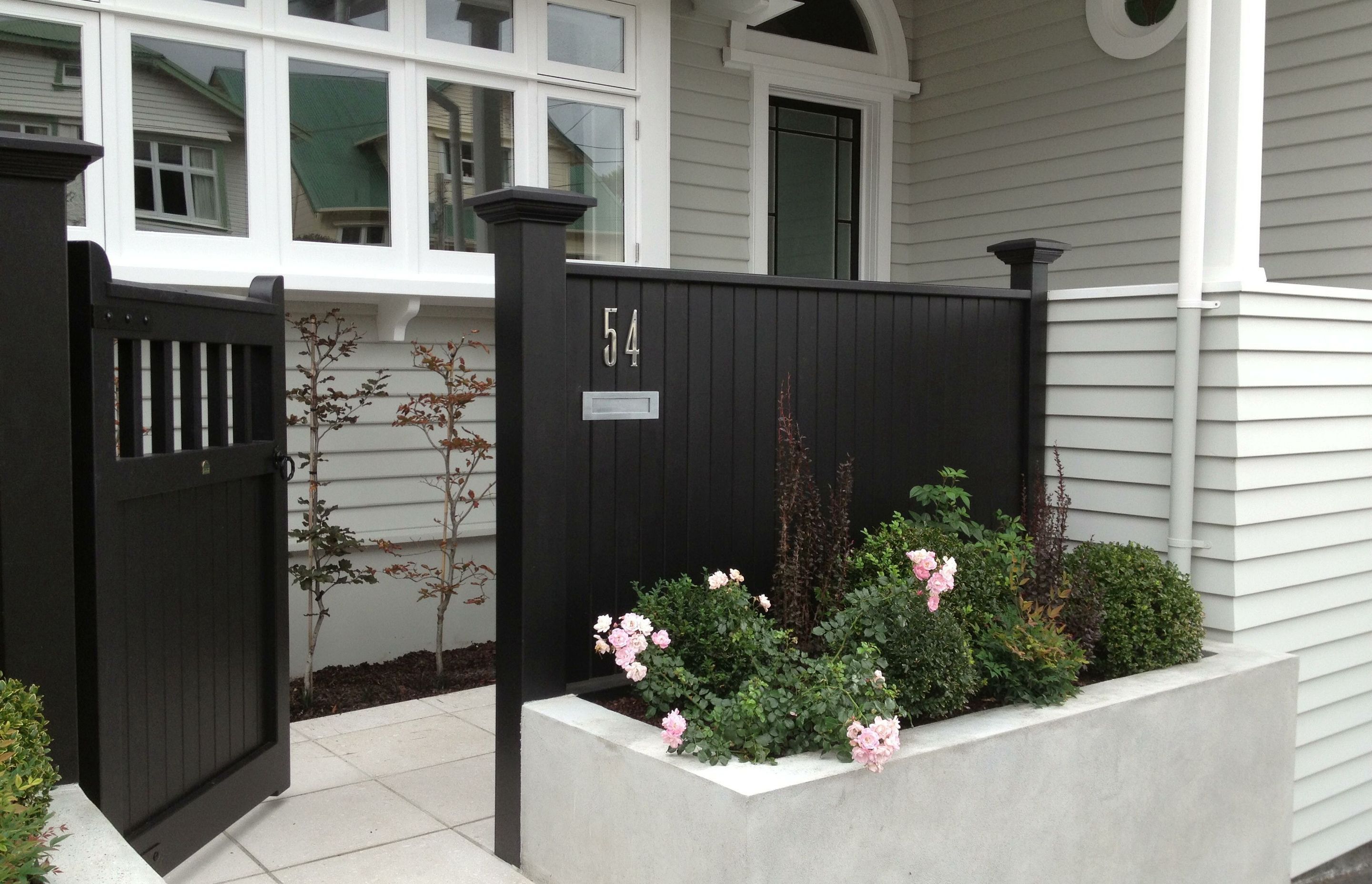 Front entrance &amp; gardens, concrete paving, plaster block wall &amp; black timber fence, Kelburn
