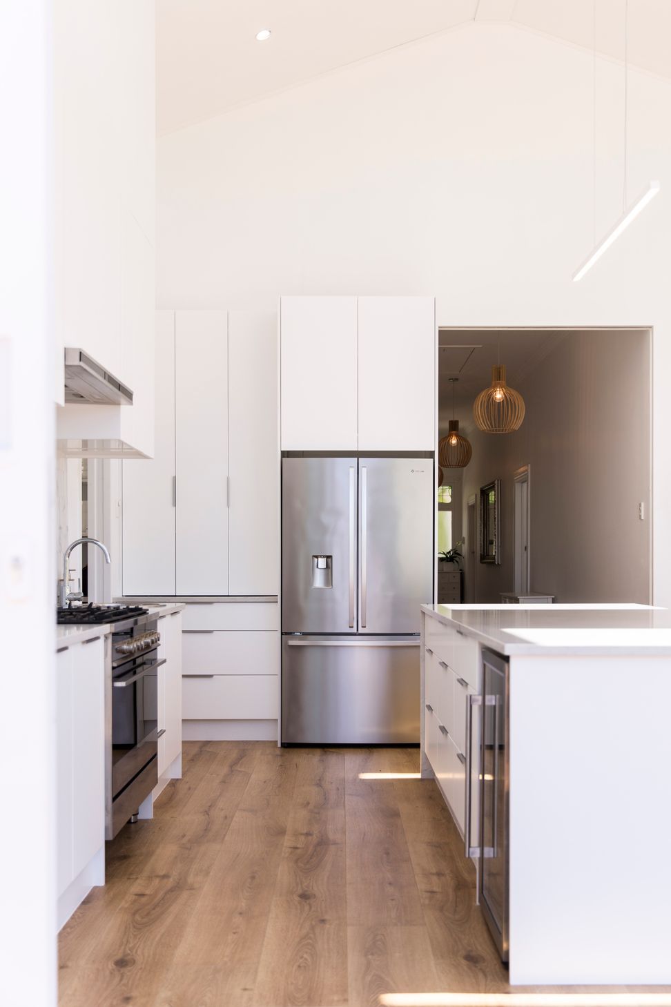 The new kitchen addition at Grey Lynn Villa — white cabinetry, marble splashback and a sloped ceiling with skylight bringing natural light deep into the plan. Macfie Architecture.