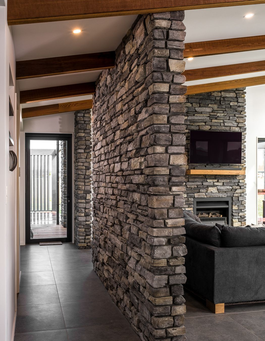 Lightweight stone veneer was used on strategic feature walls within the home to tie in the exterior stonework.