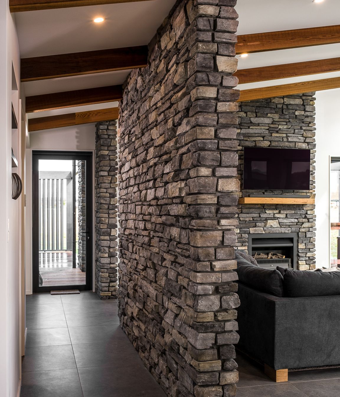 Lightweight stone veneer was used on strategic feature walls within the home to tie in the exterior stonework.