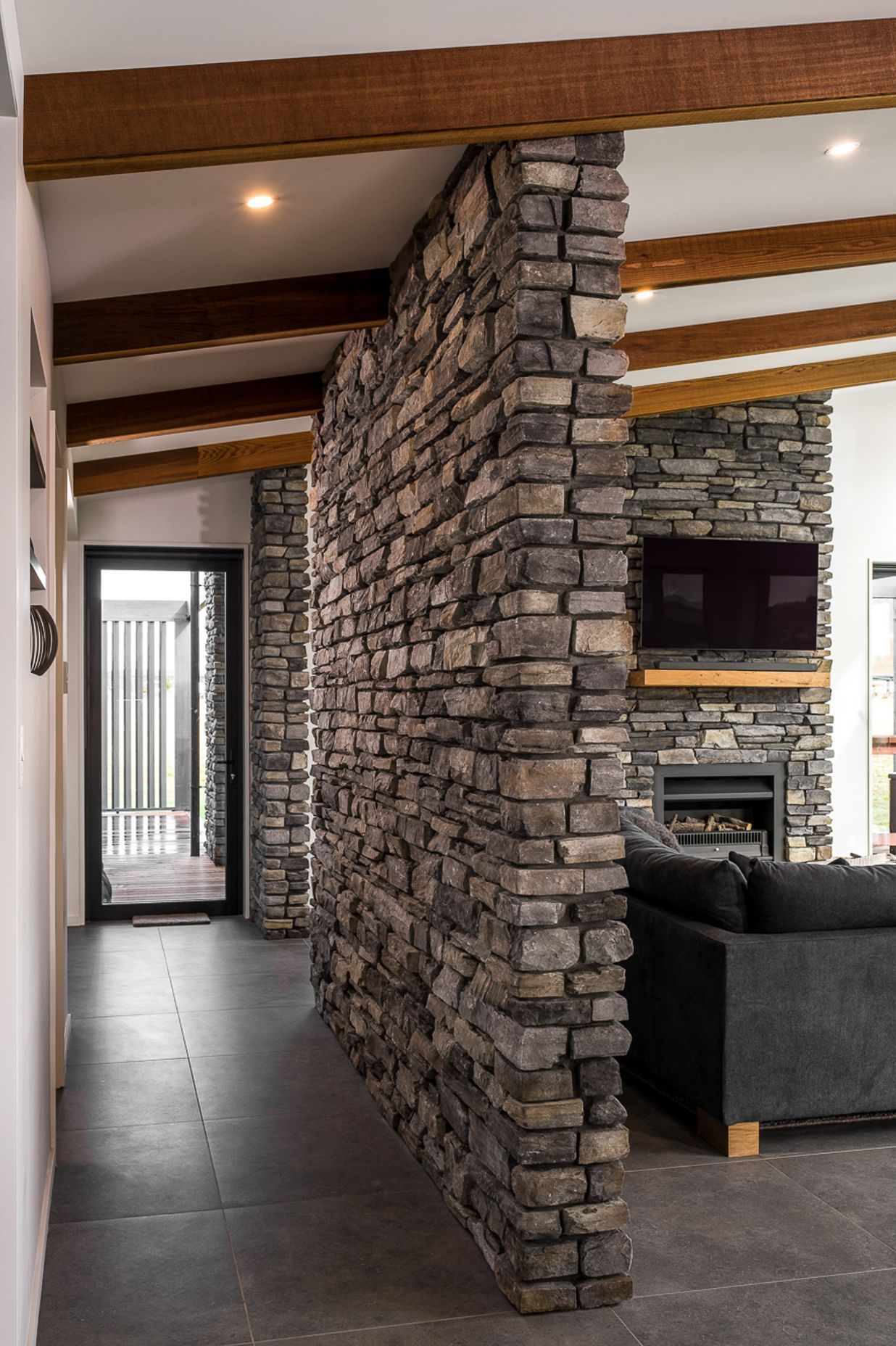 Lightweight stone veneer was used on strategic feature walls within the home to tie in the exterior stonework.