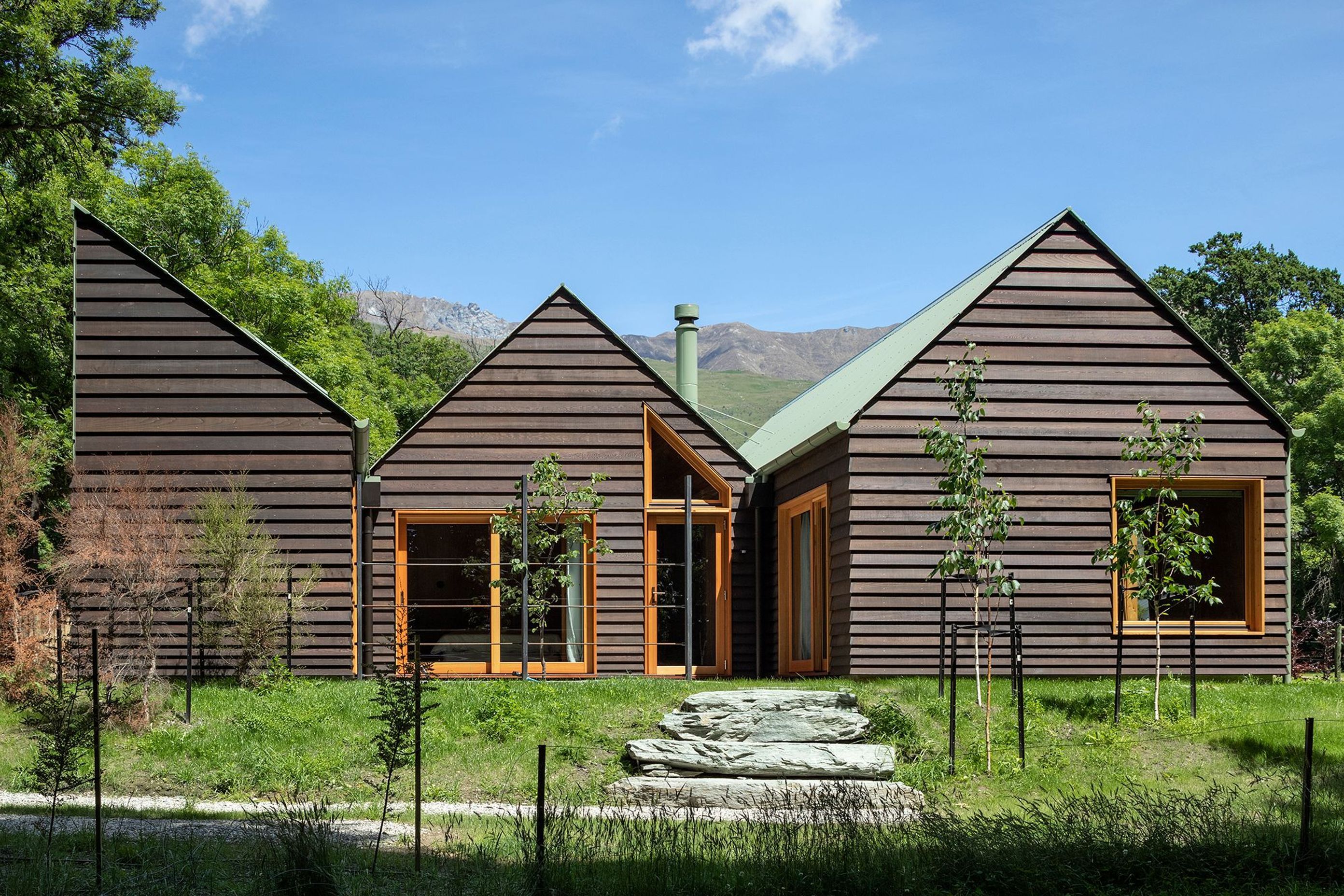 Two gable roof forms and a half gable make up the composition of Wanaka Crib, mimicking the jagged mountain rages in behind. All photography by Simon Devitt.