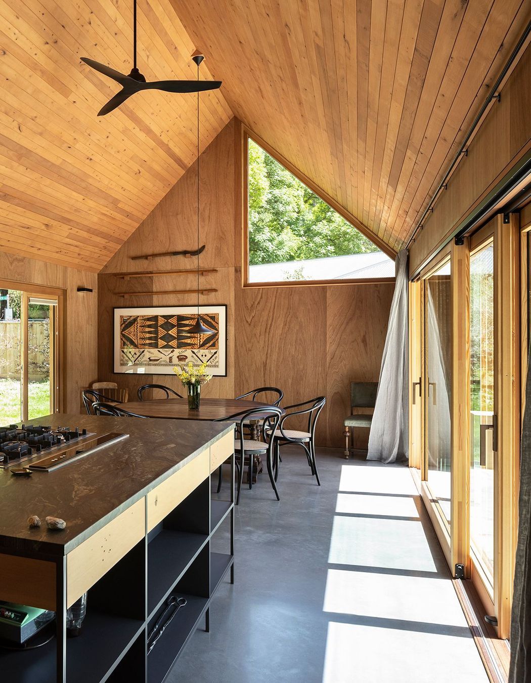 One of the largest triangular windows in this home is in the lofty dining area. 