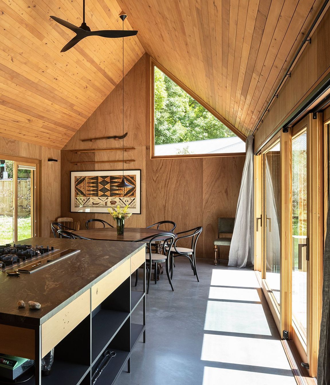 One of the largest triangular windows in this home is in the lofty dining area. 