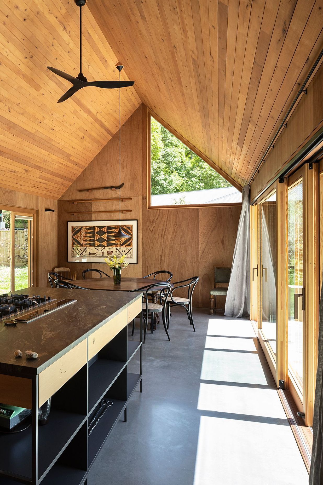 One of the largest triangular windows in this home is in the lofty dining area.