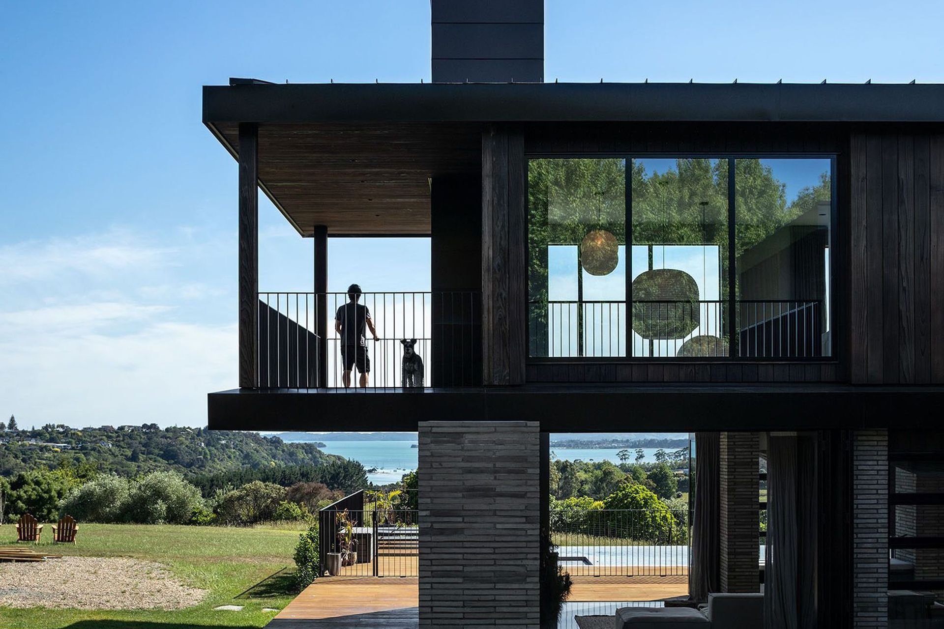 Sweeping rural valley views stretch out and across the Waitemata and beyond; a vast tapestry of deep green and blue hues towards which the house reaches out from every angle.