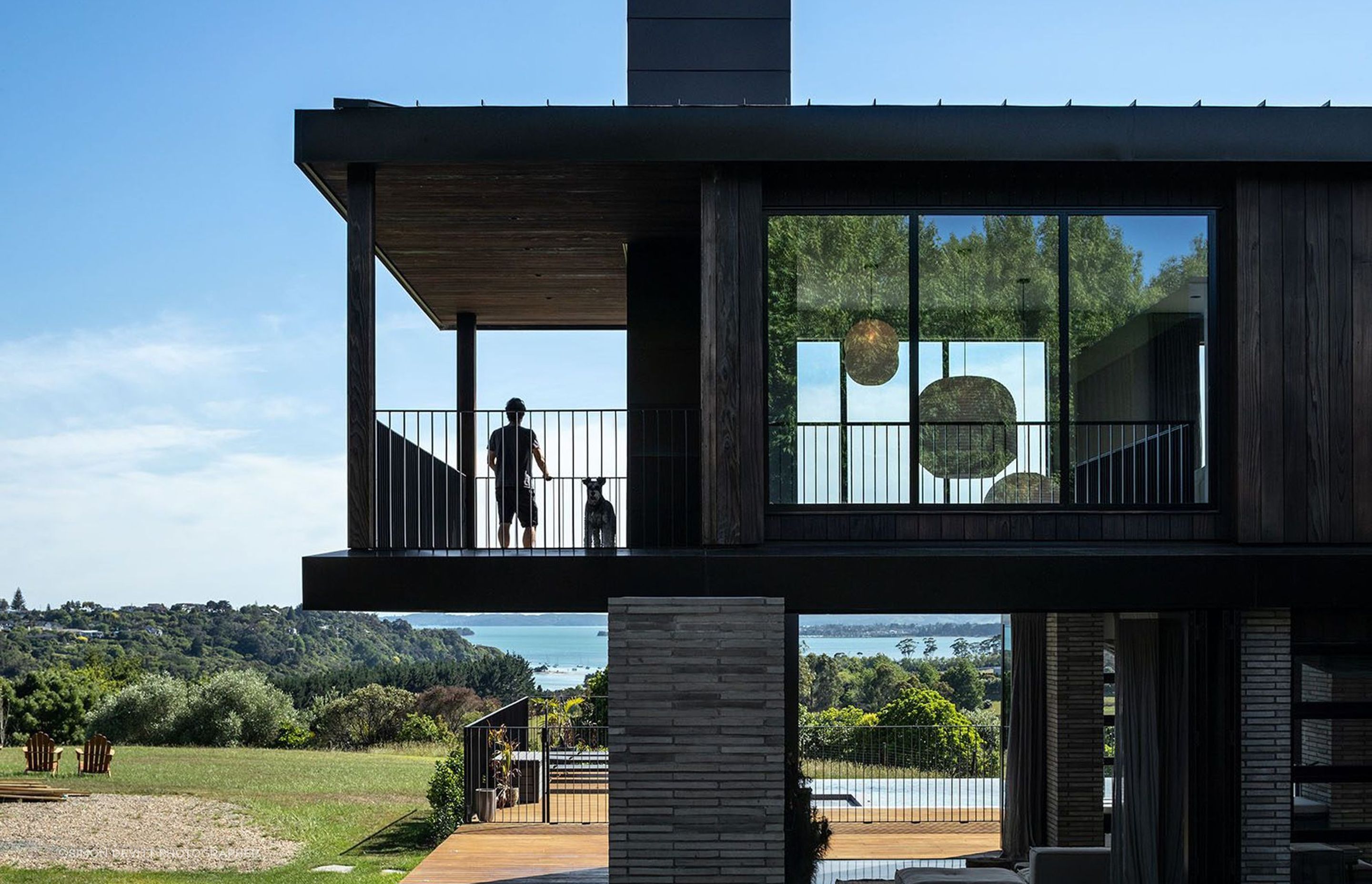 Sweeping rural valley views stretch out and across the Waitemata and beyond; a vast tapestry of deep green and blue hues towards which the house reaches out from every angle.