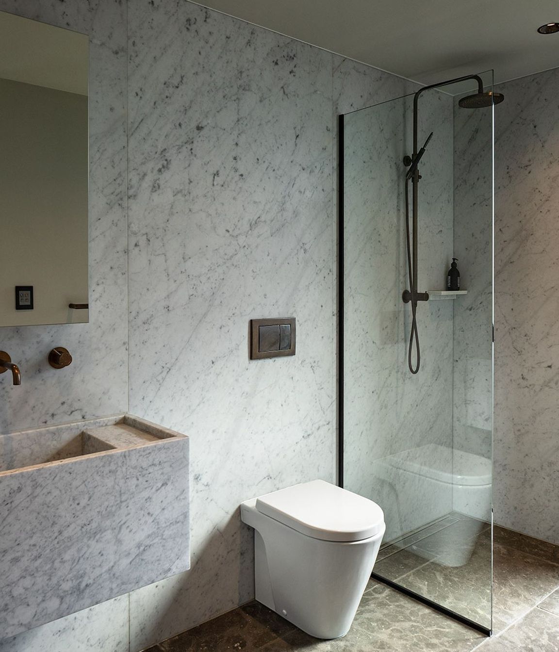 Marble-clad walls and floors combine with sculptured wall-hung basins in the bathrooms.
