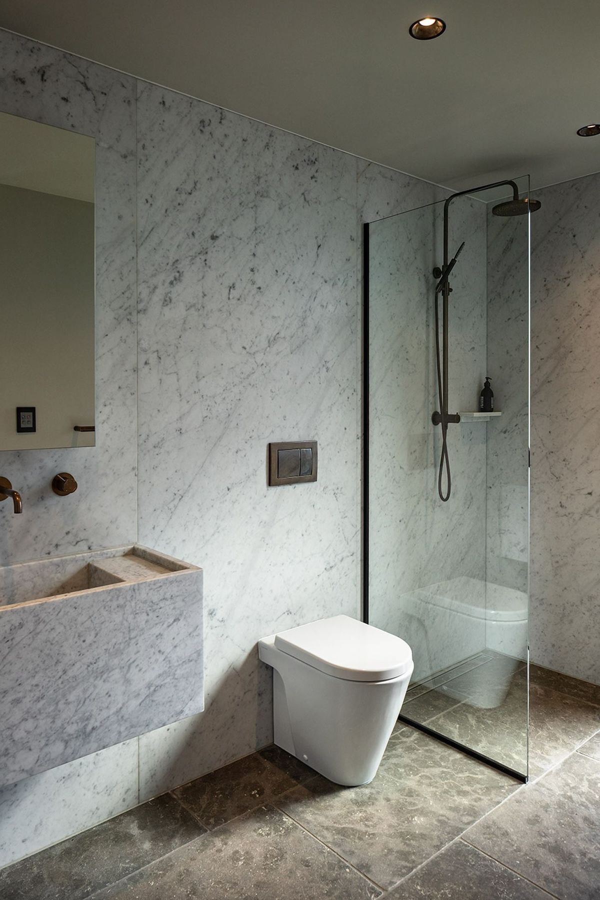 Marble-clad walls and floors combine with sculptured wall-hung basins in the bathrooms.