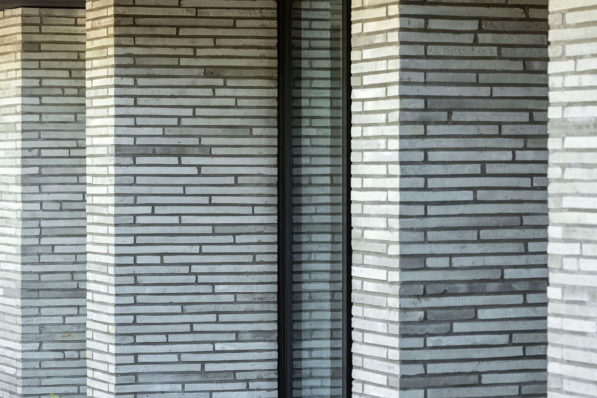 Imported from Denmark, these handmade Petersen bricks are each unique, some with visible thumbprints, details that create a sense of narrative and grounding to the lower level. 