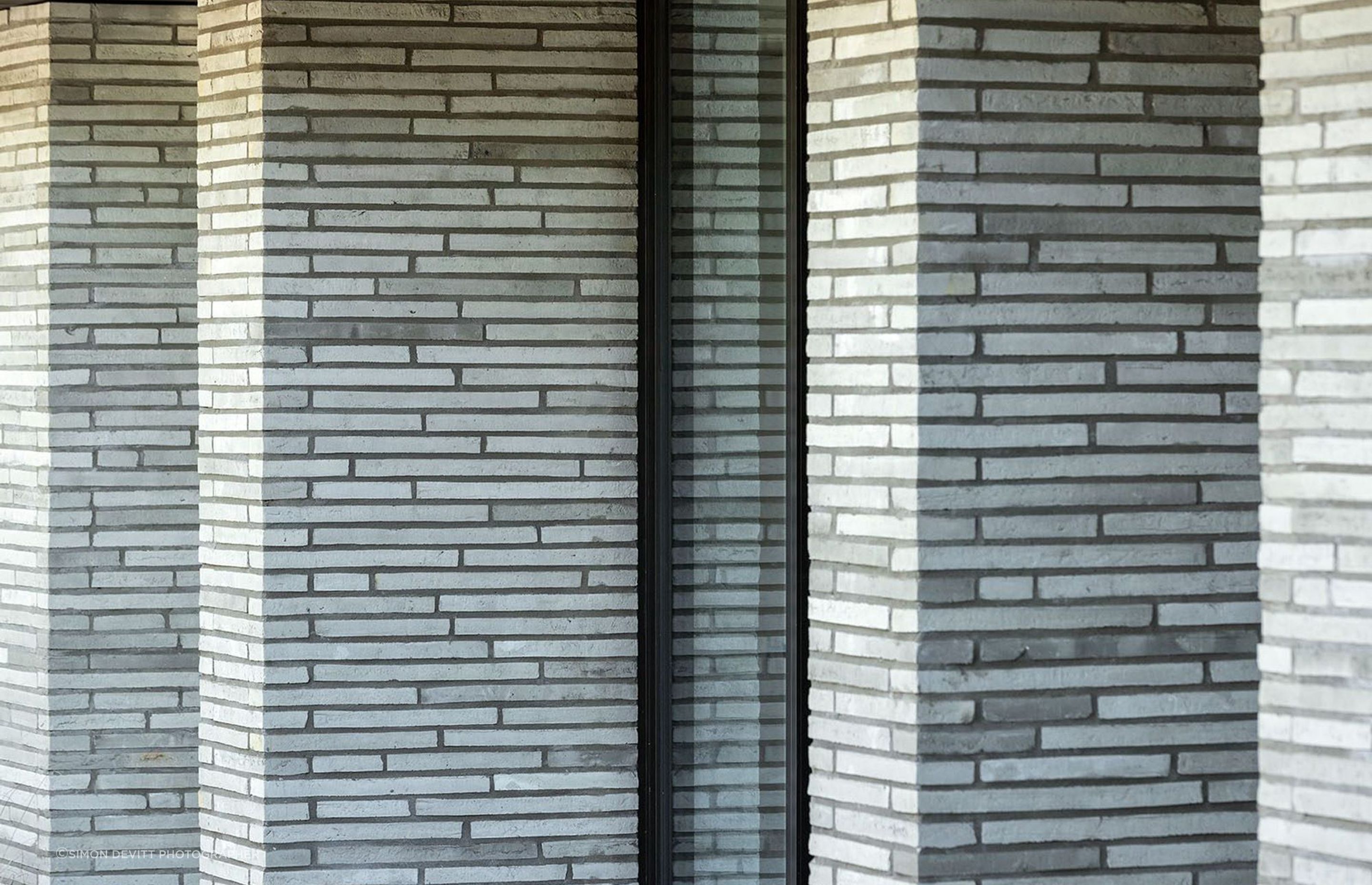 Imported from Denmark, these handmade Petersen bricks are each unique, some with visible thumbprints, details that create a sense of narrative and grounding to the lower level.