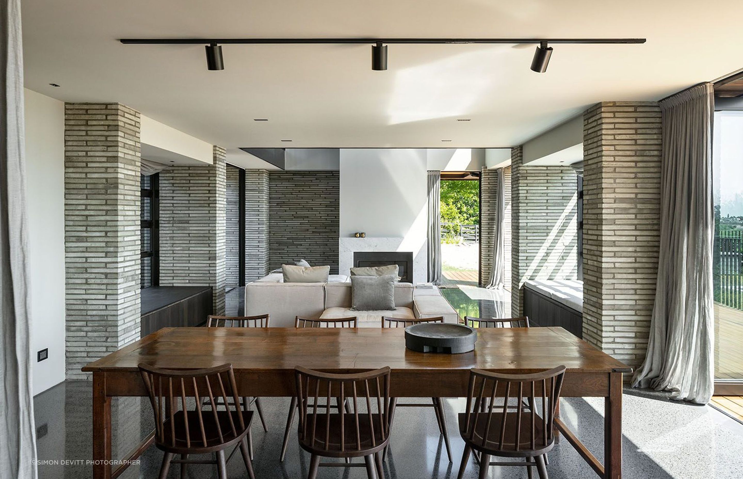 A balance between permanence and fragility features strongly in this home. Here, linen curtains juxtapose brick wing walls. 