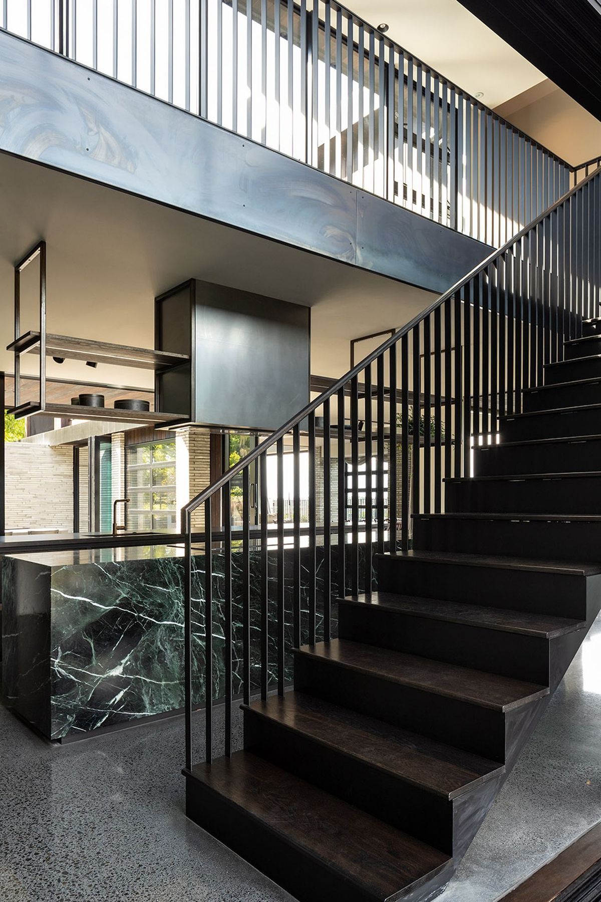 A striking steel balustrade leads to the upper pavilion that houses the private areas of the house.