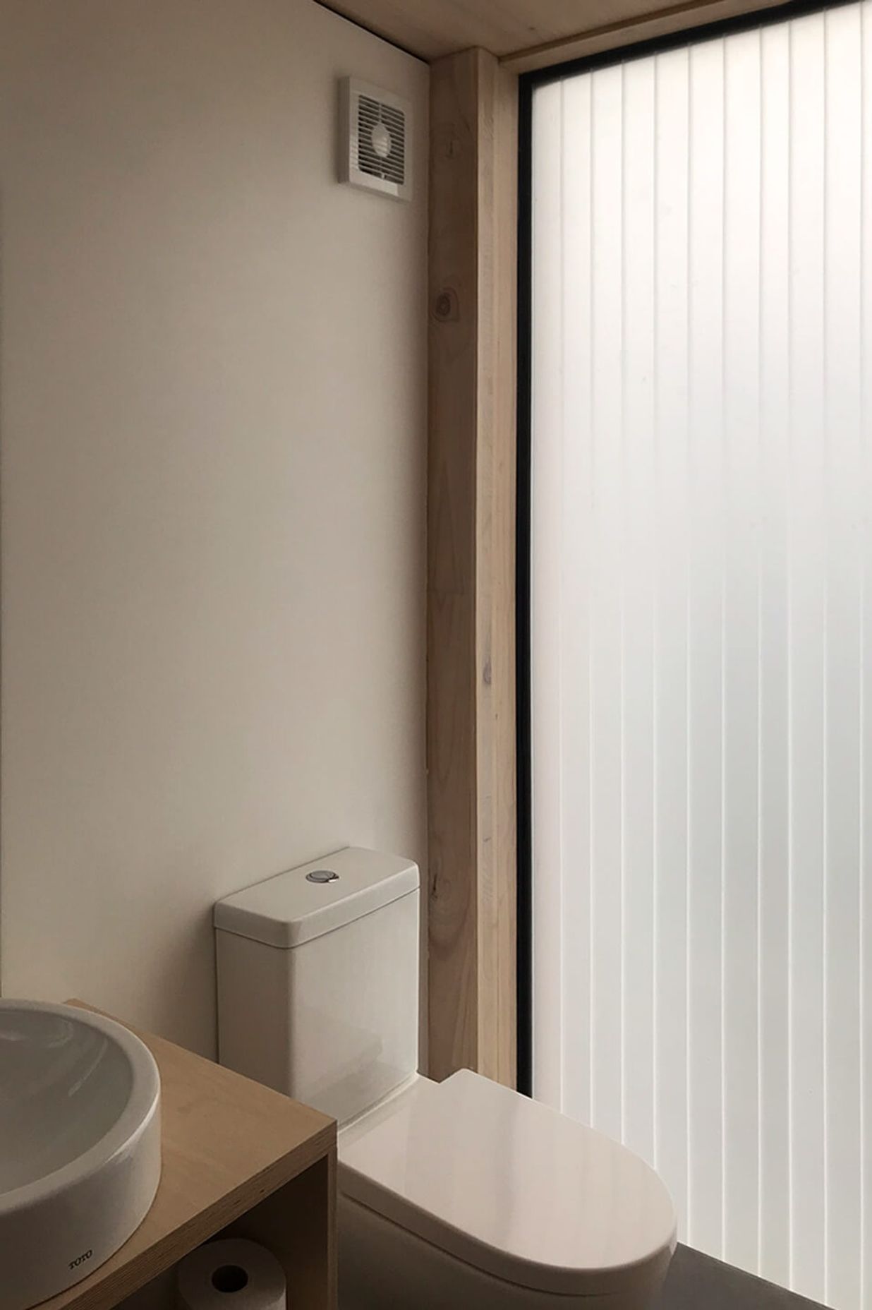 A polycarbonate slot in the wall fills the bathroom with light.