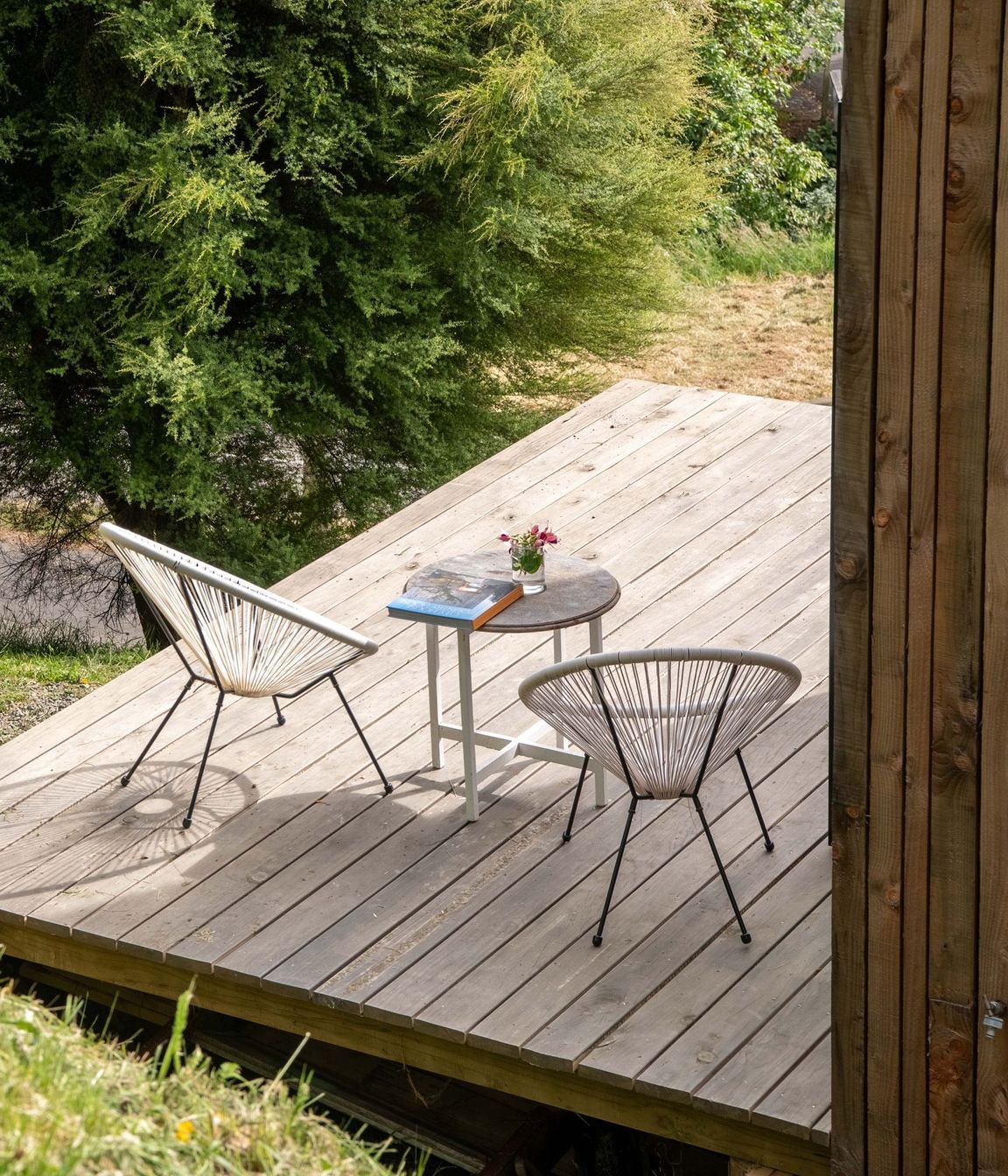 The timber deck with acapulco chairs is the perfect place to relax and listen to the nearby birdsong.
