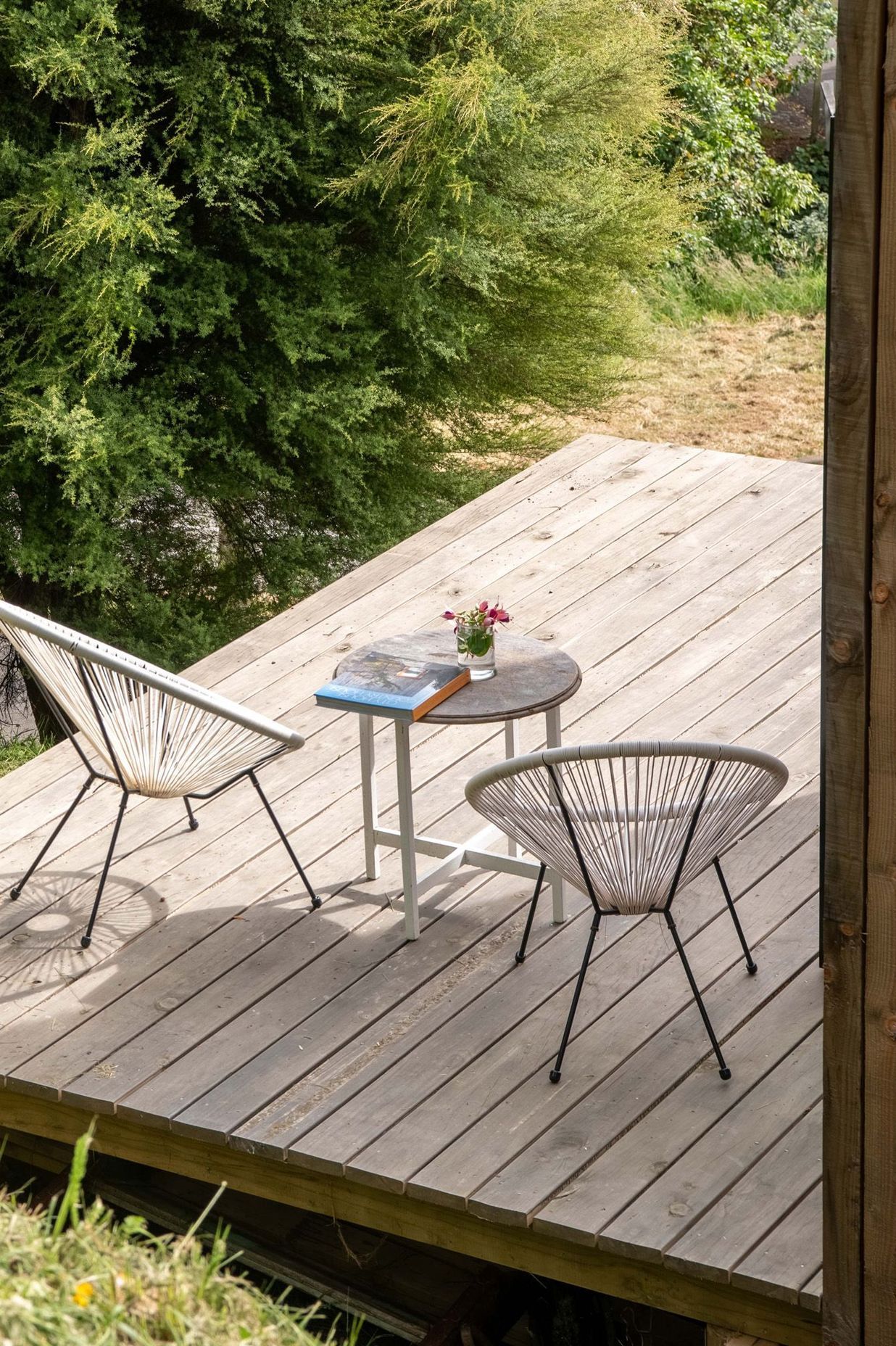 The timber deck with acapulco chairs is the perfect place to relax and listen to the nearby birdsong.
