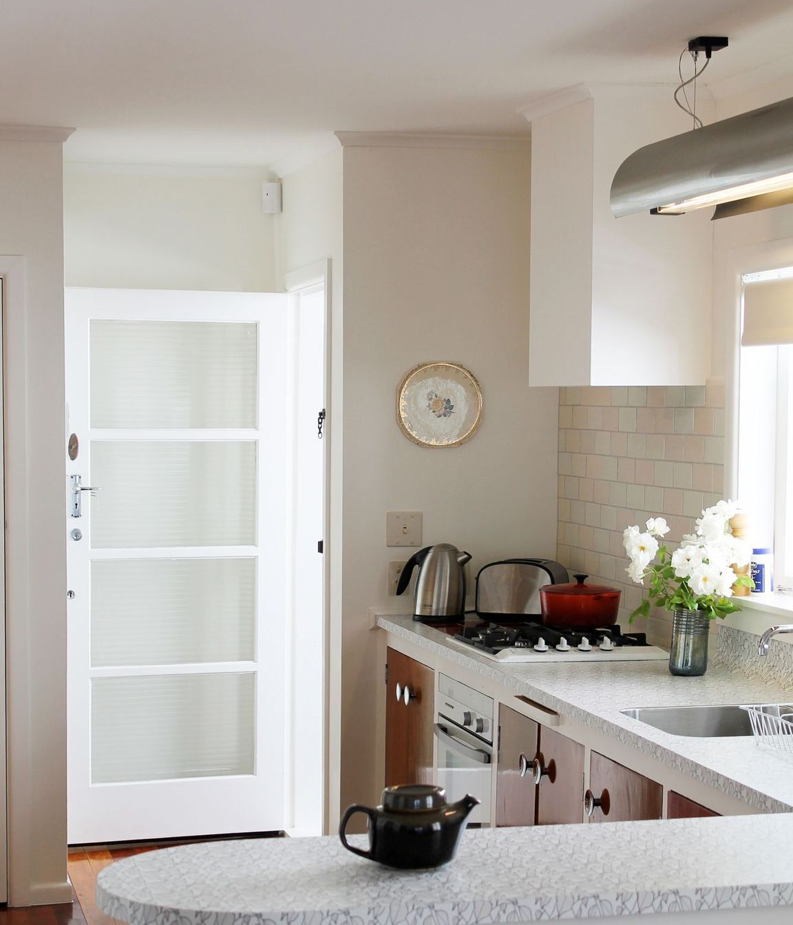 At the client's request, we designed and had this task light made to be hung over the sink. It complements the stainless steel handles and the soft 1950s curves used in the kitchen.