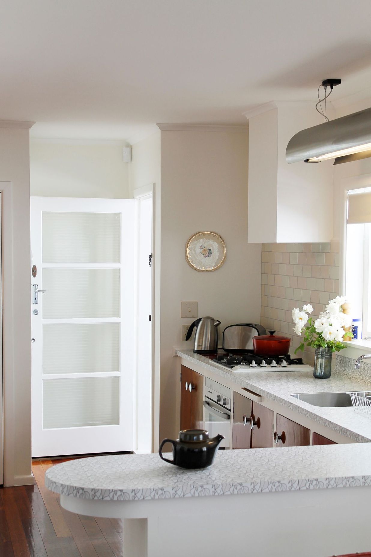 At the client's request, we designed and had this task light made to be hung over the sink. It complements the stainless steel handles and the soft 1950s curves used in the kitchen.